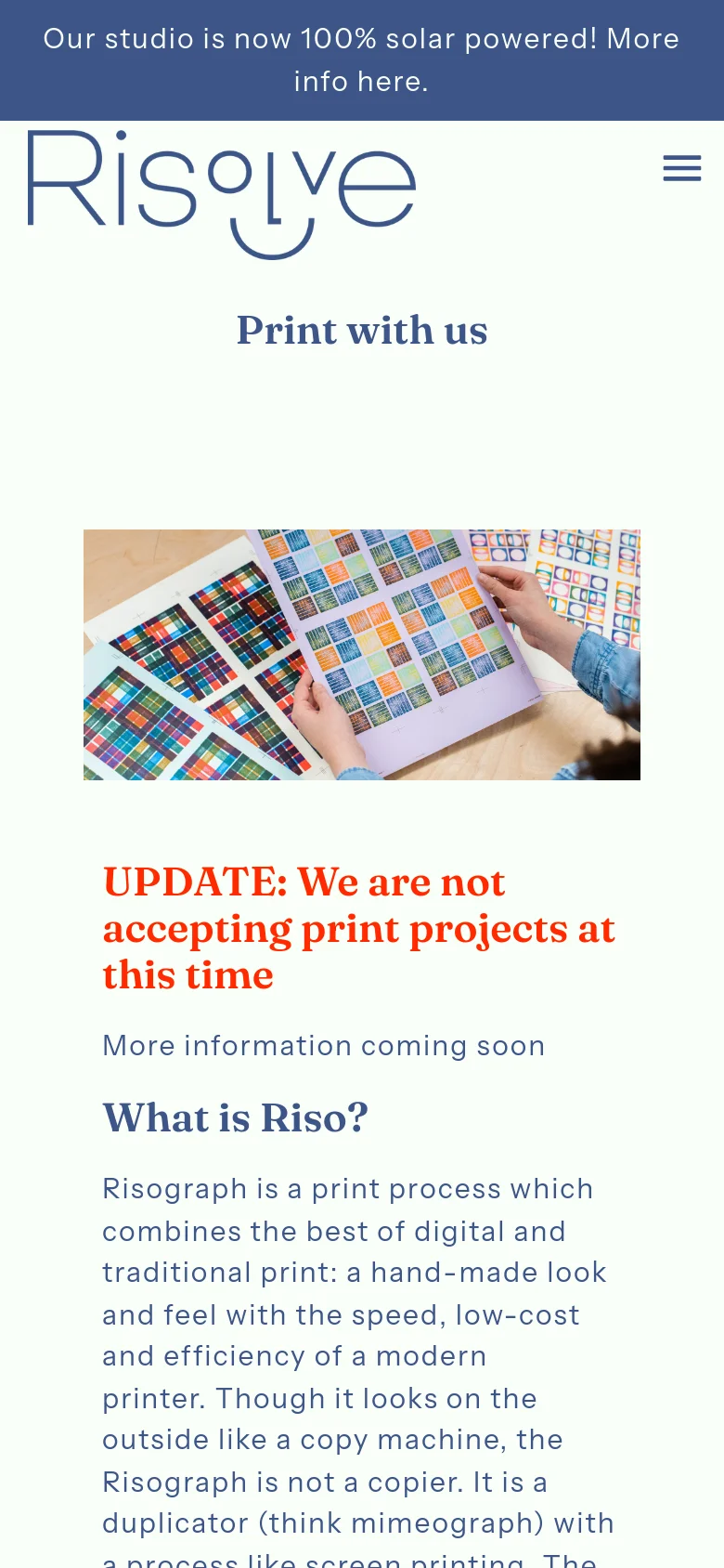 The mobile version uses a simplified layout with a hamburger menu and a blue announcement banner. The hero image and 'Print with us' headline are centered, followed by the red update text and informational sections about Risograph printing, optimized for vertical scrolling.