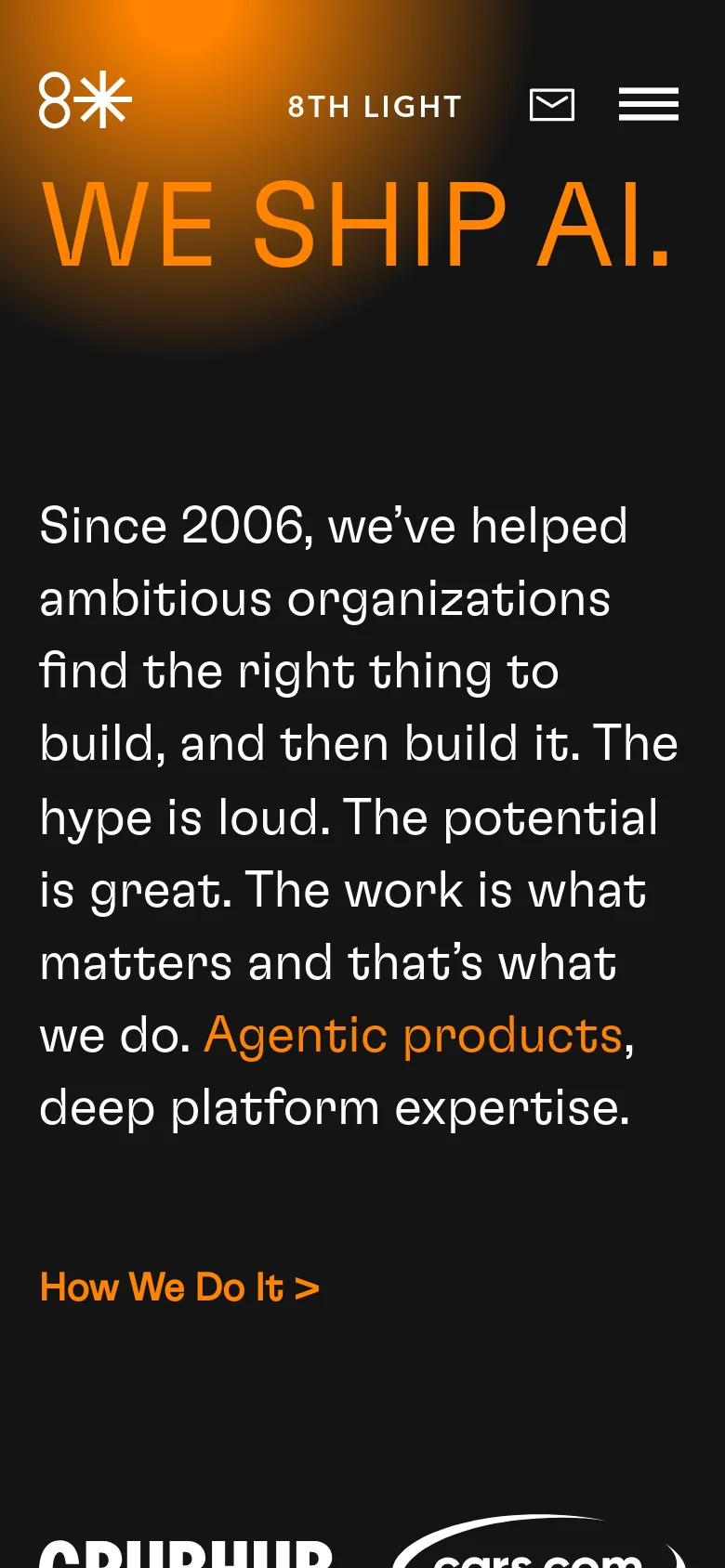 The mobile version presents a vertically stacked layout with the same dark theme and orange gradient. The 'WE SHIP AI.' headline and introductory text are centered and scaled for a smaller screen, followed by the 'How We Do It >' link. The header contains the logo, company name, email icon, and a prominent hamburger menu icon.
