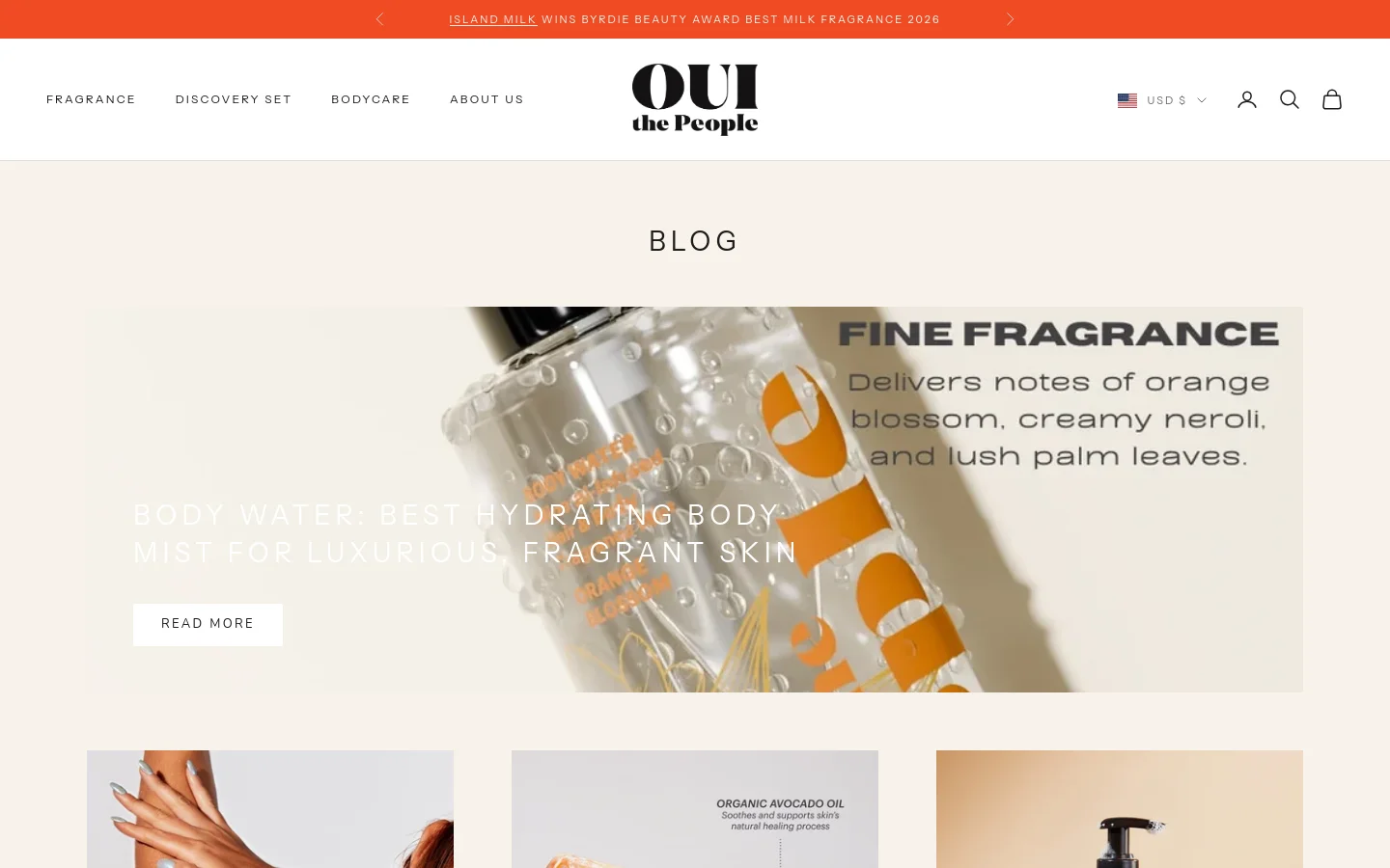 The desktop blog page features a minimalist white and beige design with a large hero image showcasing a clear bottle of Body Water mist. A prominent headline reads 'BODY WATER: BEST HYDRATING BODY MIST FOR LUXURIOUS, FRAGRANT SKIN' with a 'READ MORE' button. Below the hero section, a grid of blog posts begins, each featuring a large image, title, and excerpt.