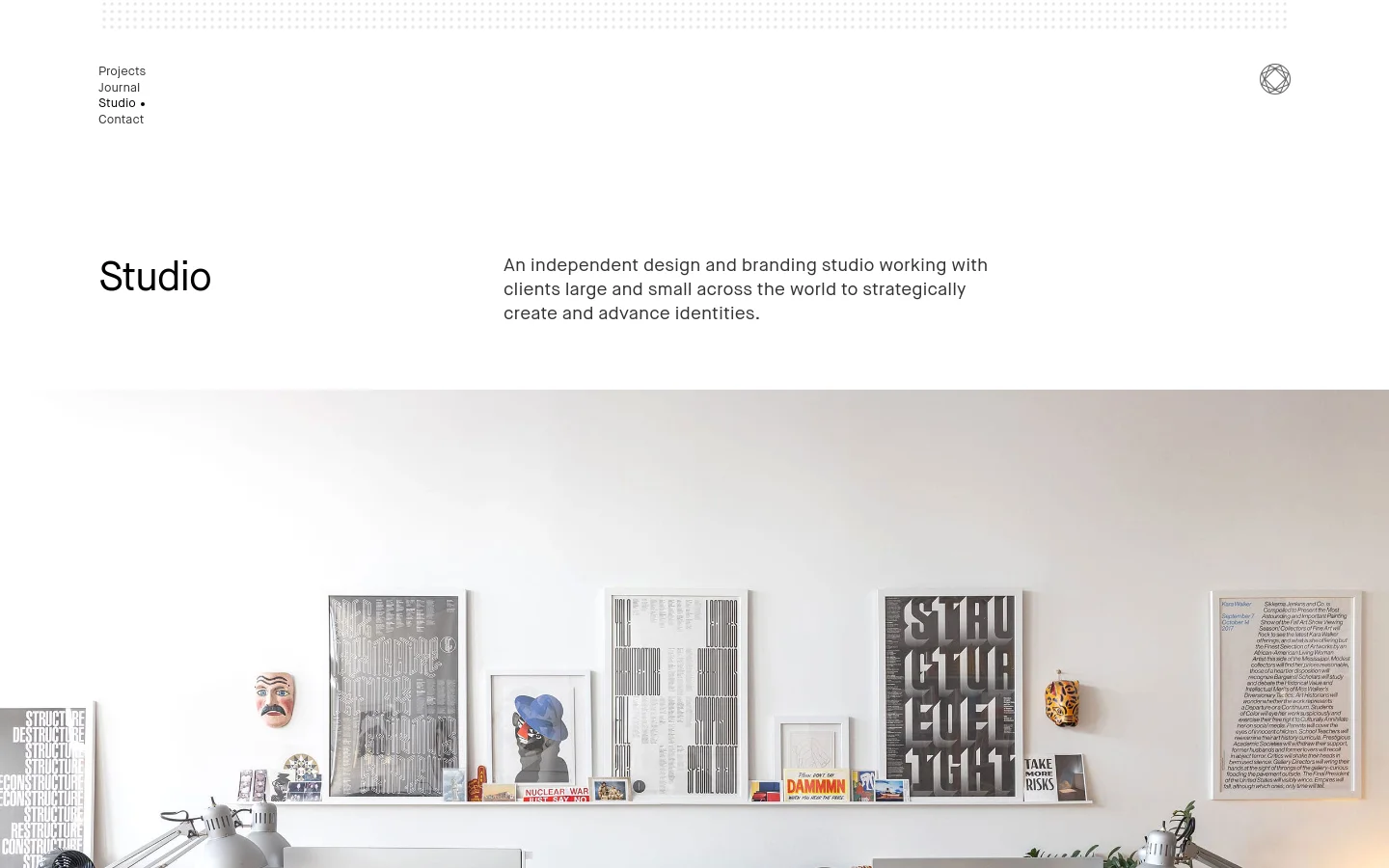 The desktop version features a minimalist white layout with a navigation menu on the top left and a small logo on the top right. A large 'Studio' headline is followed by a brief mission statement, positioned next to a wide hero image showing a bright, modern office space with a desk, computers, and framed art on the wall.