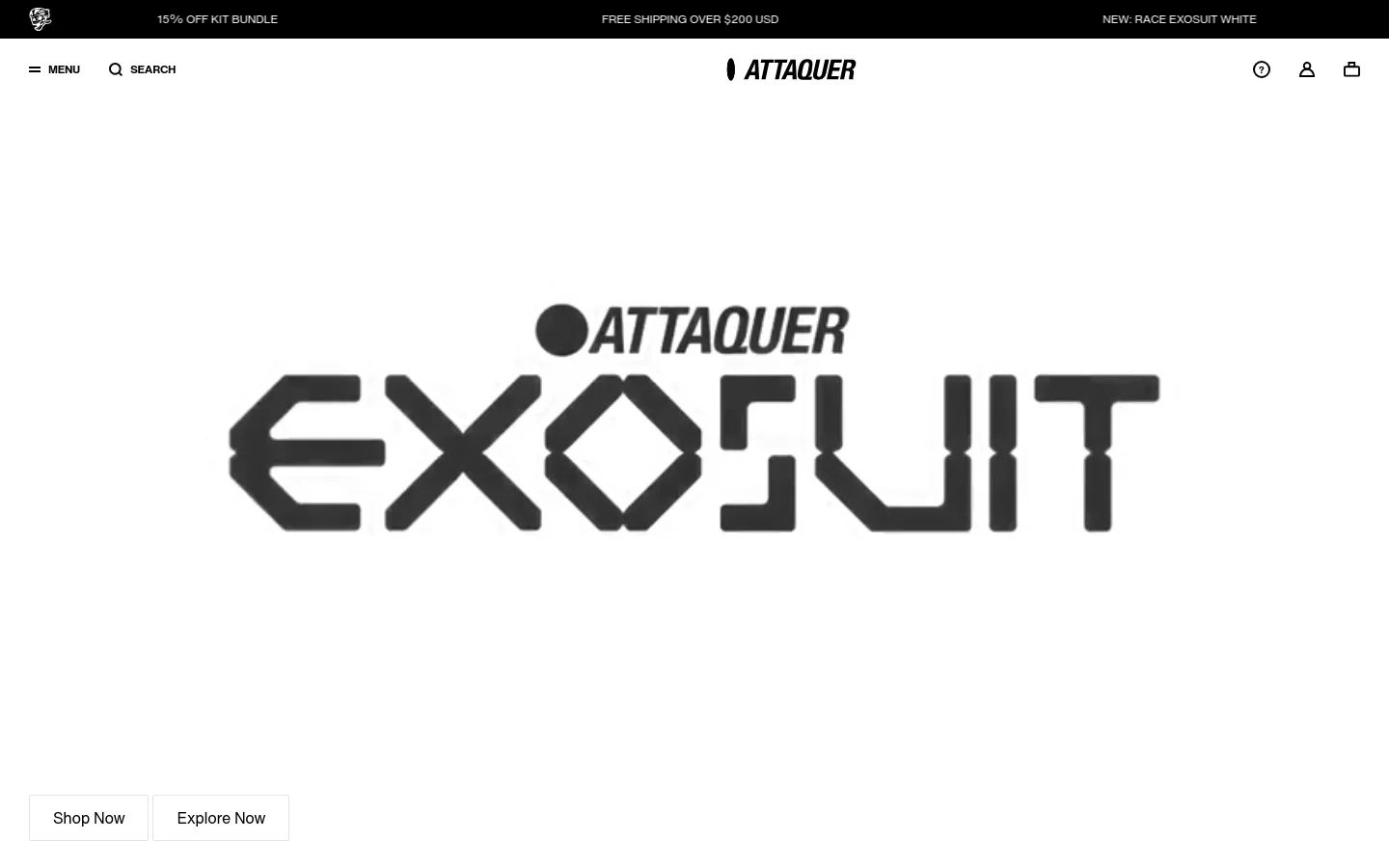 The desktop homepage features a minimalist white background with a large, bold black graphic reading 'ATTAQUER EXOsuit'. Below the central graphic are two side-by-side buttons labeled 'Shop Now' and 'Explore Now'. A clean navigation bar at the top includes a menu icon, search, brand logo, help, account, and shopping bag icons.