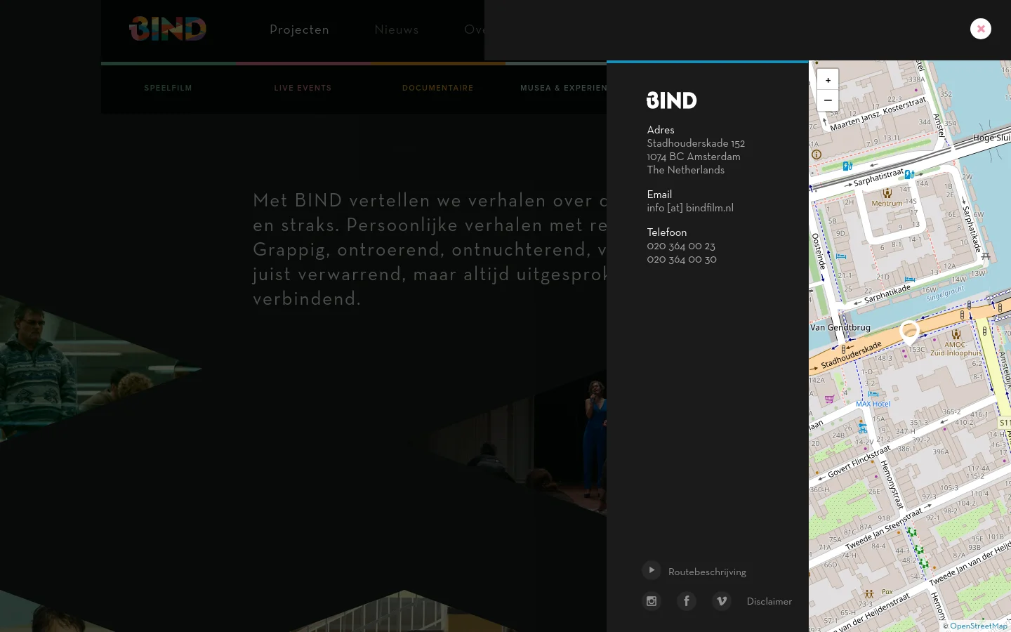 The desktop contact page features a dark, minimalist layout with a large map on the right side and contact details on the left. A large 'BIND' logo sits above the address, email, and phone number information, which is set against a dark background with subtle architectural imagery. The navigation menu is visible at the top, and a 'Routebeschrijving' button is located at the bottom left.