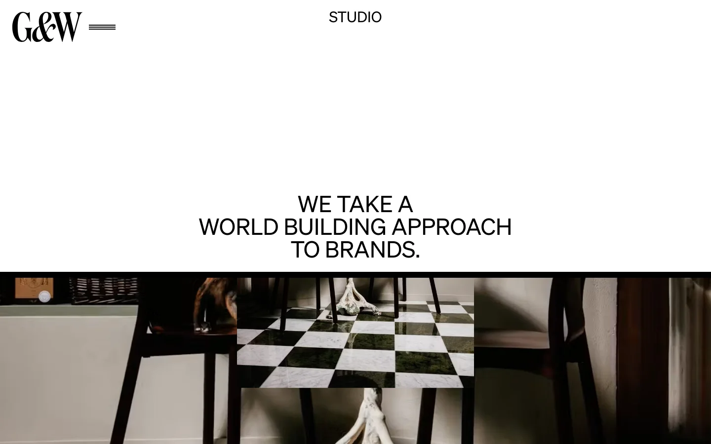 The desktop About page features a minimalist white background with the G&W logo and a navigation menu at the top. A large centered headline reads, 'WE TAKE A WORLD BUILDING APPROACH TO BRANDS,' positioned above a wide, cinematic photograph of a checkered floor and dark furniture.
