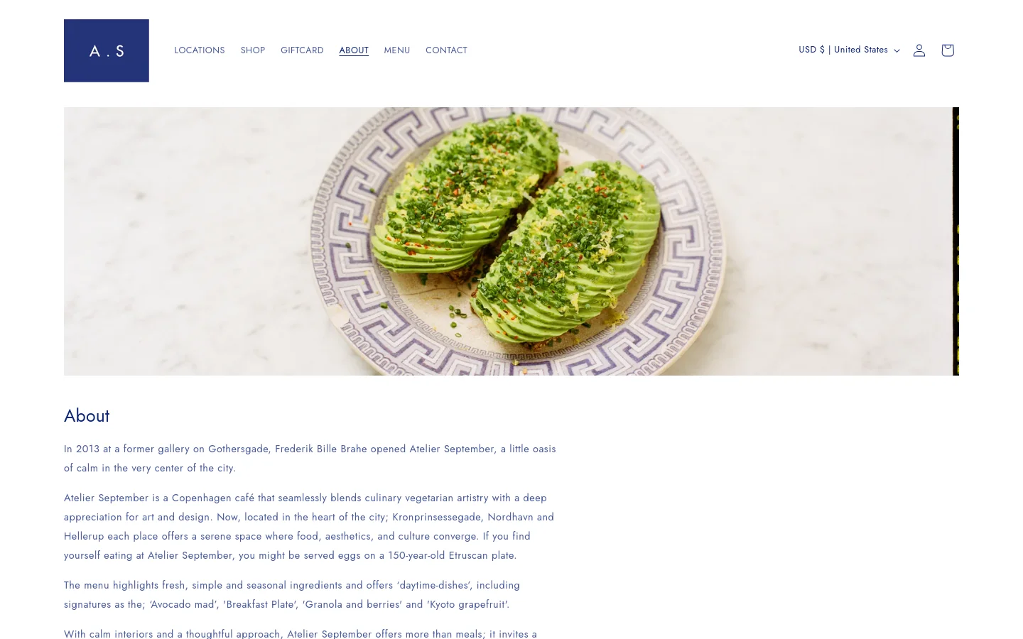 The desktop About page features a minimalist white layout with a large hero image of sliced avocado on a decorative patterned plate. A clean navigation bar at the top includes links for Locations, Shop, Giftcard, About, Menu, and Contact. The text content is arranged in a single column below the hero image, detailing the café's history and team.