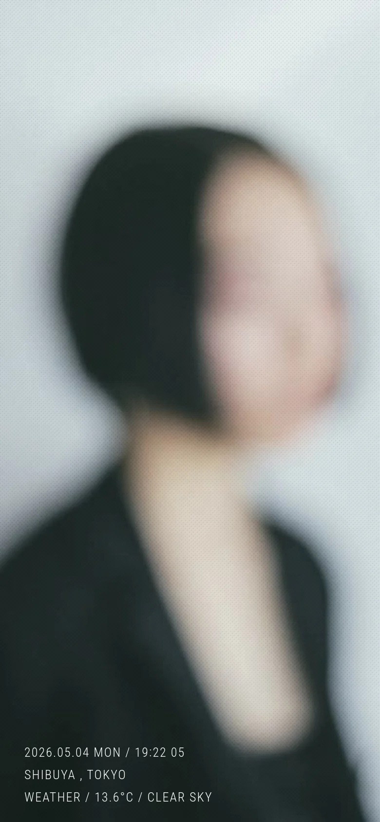 The mobile version maintains the minimalist aesthetic with the same soft-focus portrait filling the screen. The navigation links and bottom text information are repositioned to accommodate the vertical aspect ratio, ensuring a clean and centered visual flow.