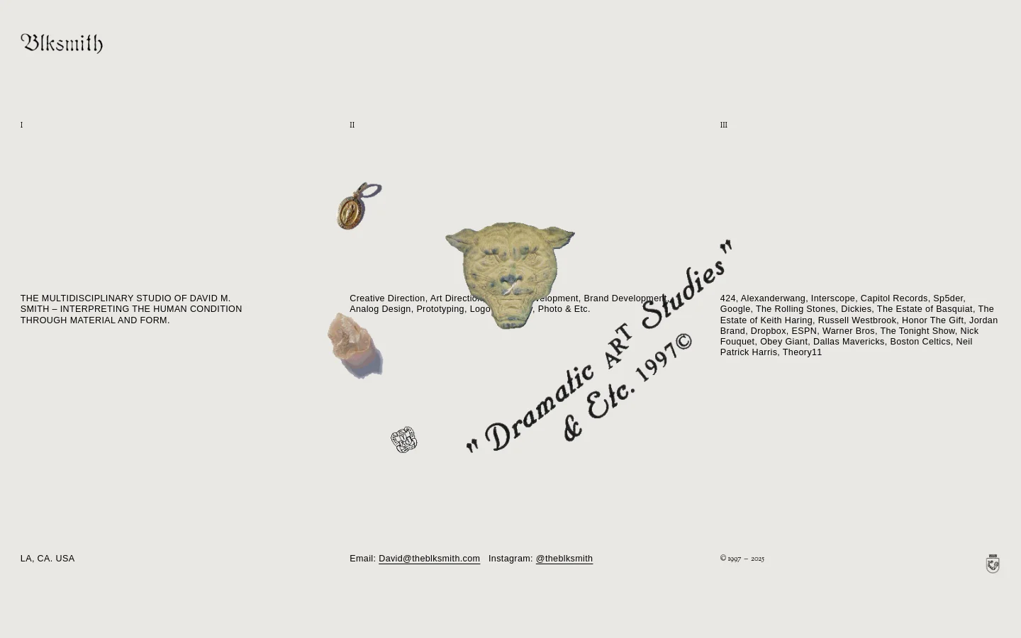 The desktop homepage features a minimalist, light gray background with black serif typography. A central hero area displays a collage of artistic objects, including a gold pendant and a textured animal head, surrounded by large headlines describing the studio's multidisciplinary services and client list.