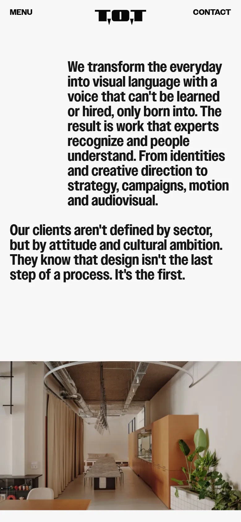 The mobile version maintains the minimalist aesthetic but uses a vertical layout. The text is stacked for readability, and the studio interior photograph is scaled to fit the narrower screen width. The top navigation is replaced by a 'MENU' button, and the footer information is condensed.
