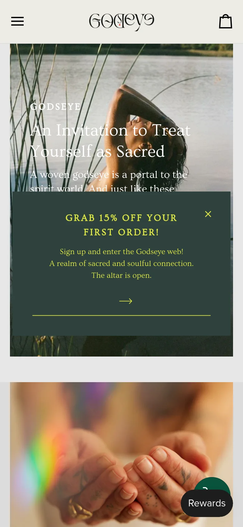 The mobile version presents a vertically stacked layout, beginning with a large hero image of a person in nature with centered white text. A dark green promotional pop-up overlay for a 15% discount is prominently displayed in the middle of the screen. The navigation is condensed into a hamburger menu icon, and the bottom of the screen features a floating 'Rewards' button.