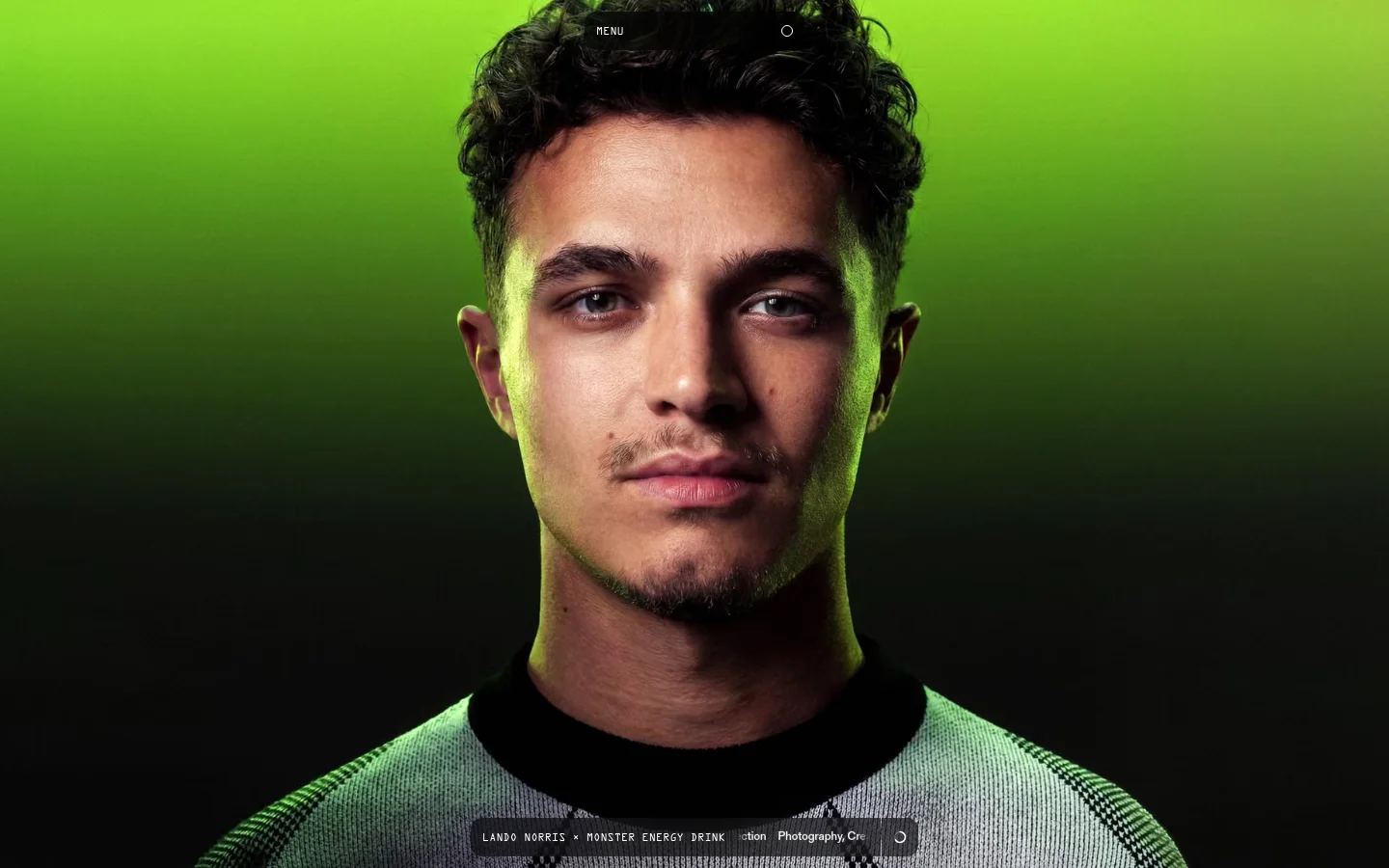 The desktop homepage features a large, high-resolution hero portrait of a man against a vibrant lime green background. A minimalist navigation menu with 'MENU' and a circular icon is at the top, while a translucent overlay at the bottom displays project details for 'Lando Norris x Monster Energy Drink'.