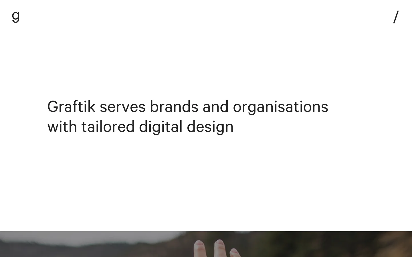 The desktop homepage features a minimalist white background with a large, bold headline stating 'Graftik serves brands and organisations with tailored digital design'. Below the hero section, a grid of large project images showcases case studies like Luminor and State Blood Donor Centre, each with a title, description, and 'View case study' link. The layout transitions into service descriptions for Brand, Web & Mobile, and Multimedia, followed by a grayscale logo slider of partners.