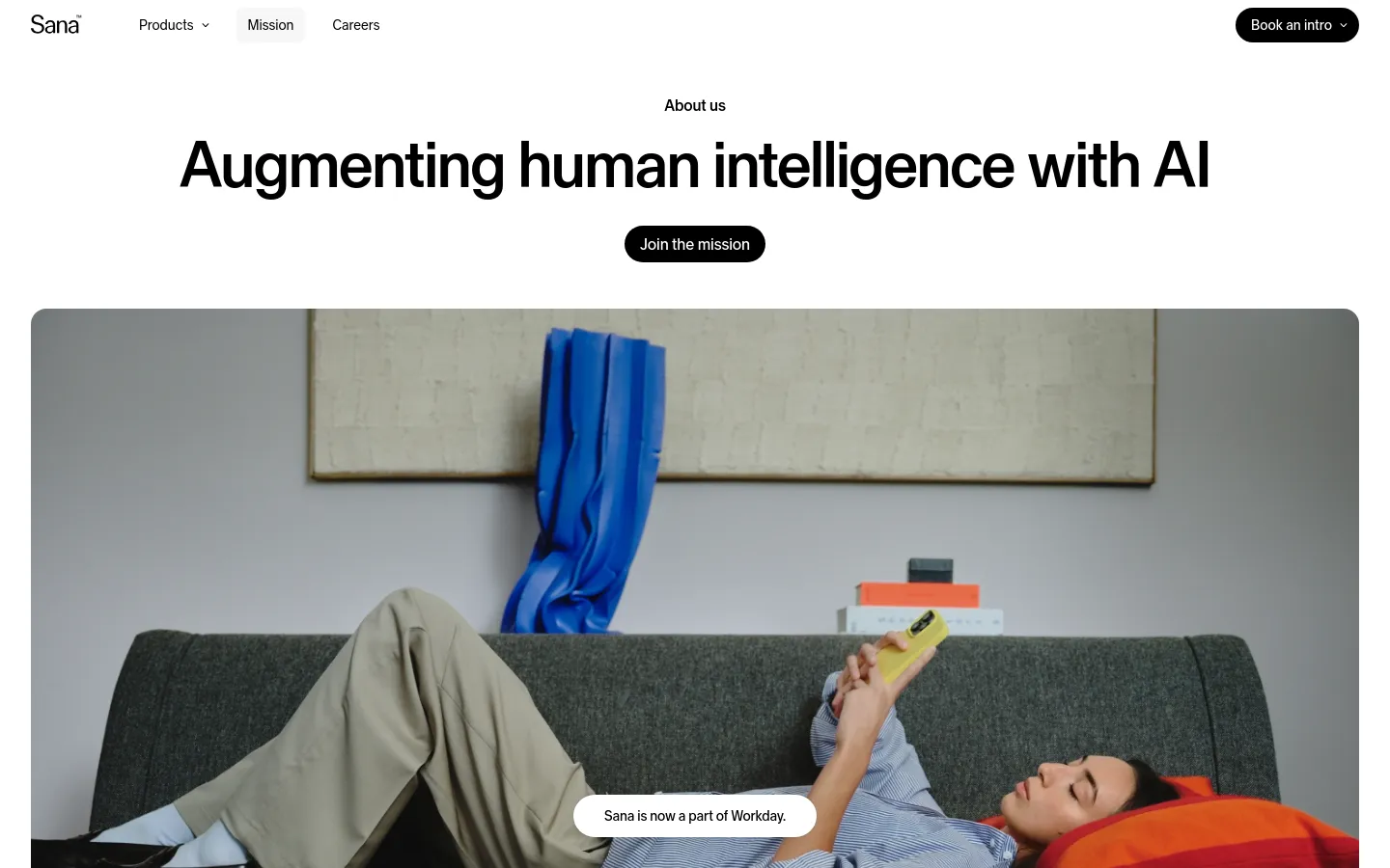 The desktop page features a clean white background with a navigation bar containing the Sana logo, product links, and a 'Book an intro' button. The hero section displays the headline 'Augmenting human intelligence with AI' above a 'Join the mission' call-to-action button and a large lifestyle image of a person relaxing on a sofa using a phone.