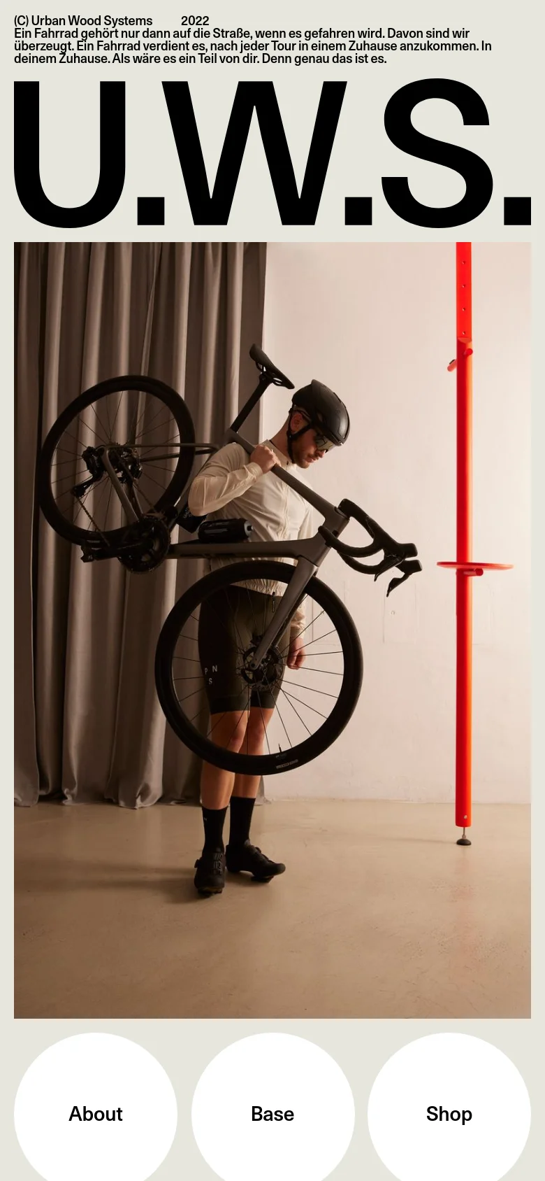 The mobile version presents a stacked layout with the large 'U.W.S.' headline at the top, followed by a full-width hero image of a person with a bicycle. Three white circular navigation buttons for 'About', 'Base', and 'Shop' are positioned at the bottom of the screen.