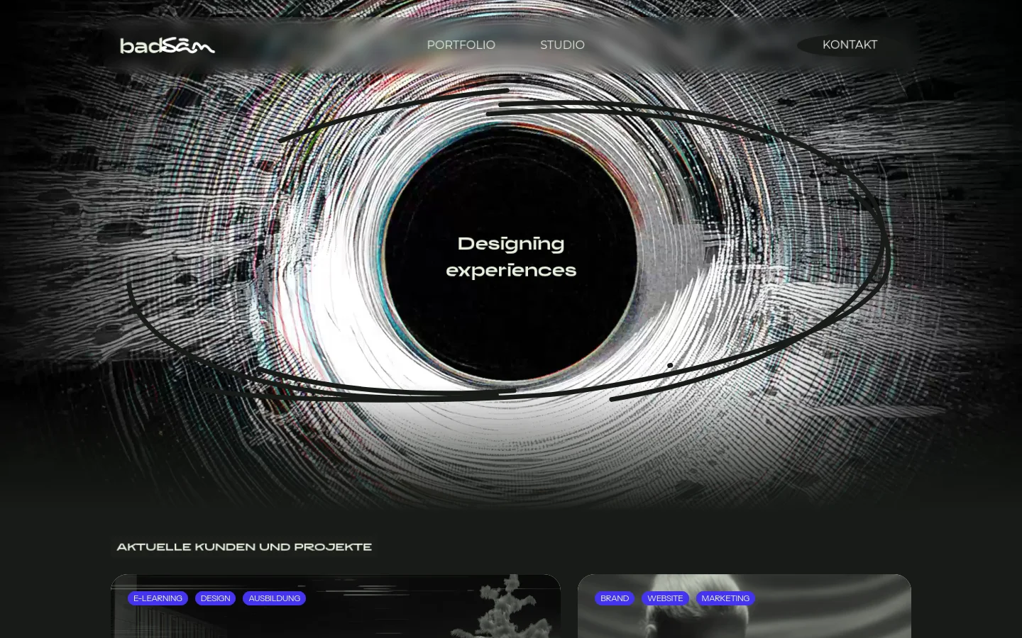 The desktop homepage features a dark, high-contrast design with a large, swirling abstract circular graphic in the center. The headline 'Designing experiences' is centered within the dark core of the graphic, and a navigation bar at the top includes the logo, 'PORTFOLIO', 'STUDIO', and a 'KONTAKT' button. Below the hero section, a heading reads 'AKTUELLE KUNDEN UND PROJEKTE' above a grid of project cards.