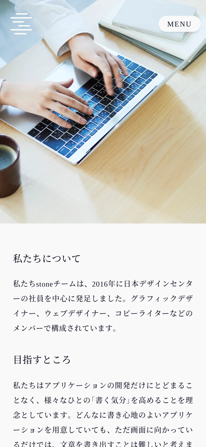 The mobile version simplifies the layout, replacing the left sidebar with a hamburger menu icon at the top left and a 'MENU' button overlaying the hero image. The hero image of the person typing remains at the top, followed by the 'About Us' text content stacked vertically in a single column.