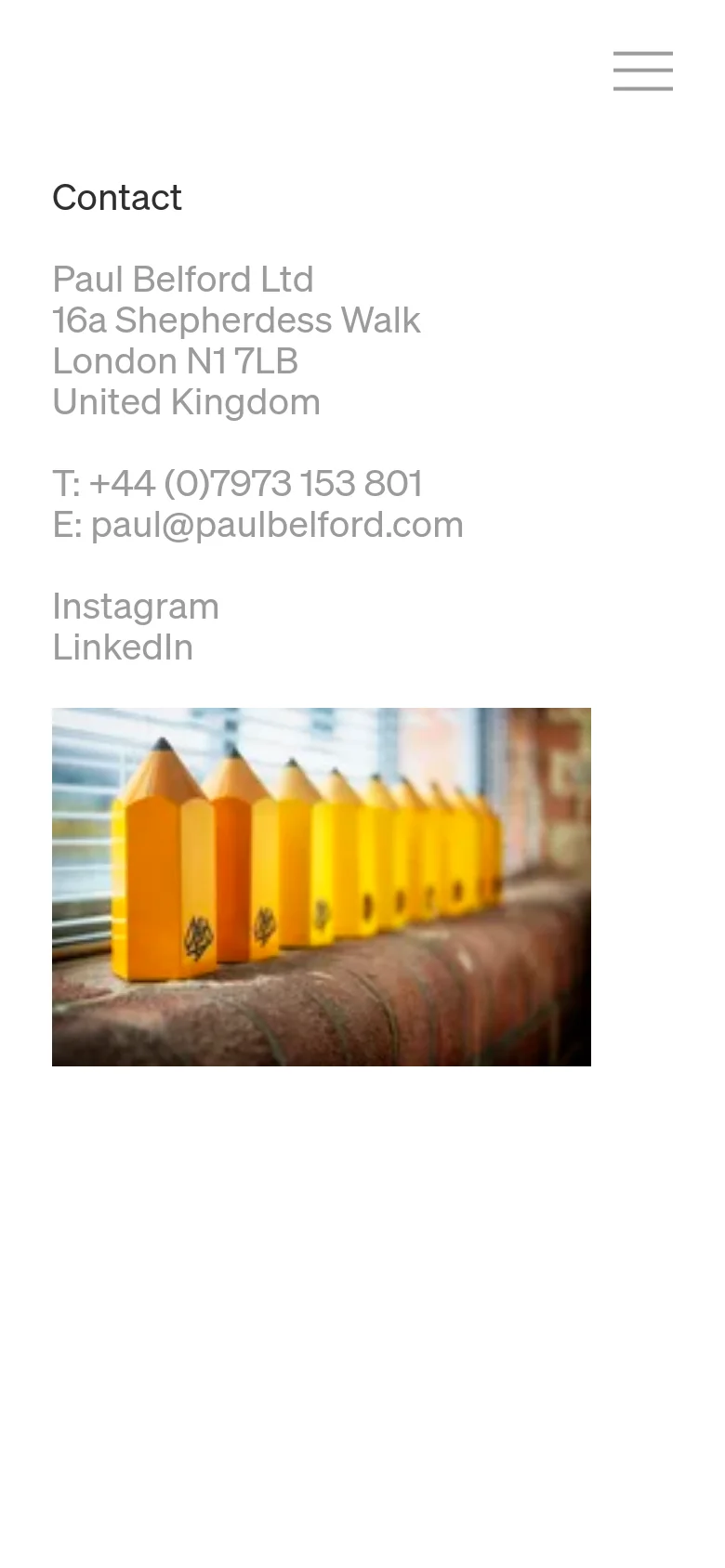 The mobile version simplifies the layout into a single vertical column. The navigation menu is collapsed into a hamburger icon at the top right, and the contact information and large yellow pencil image are stacked vertically for easier scrolling.