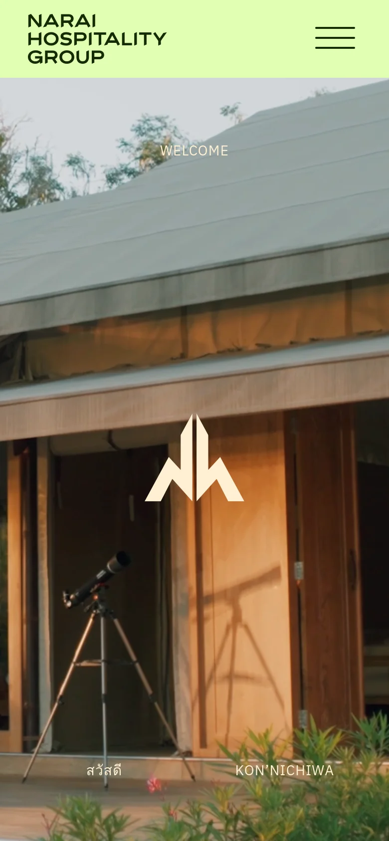 The mobile version simplifies the layout with a light green header containing the company logo and a three-line hamburger menu icon. The hero section shows a full-width, warm-toned photograph of a building exterior with a telescope in the foreground and the company logo centered. Text overlays include 'WELCOME' at the top and multilingual greetings at the bottom.