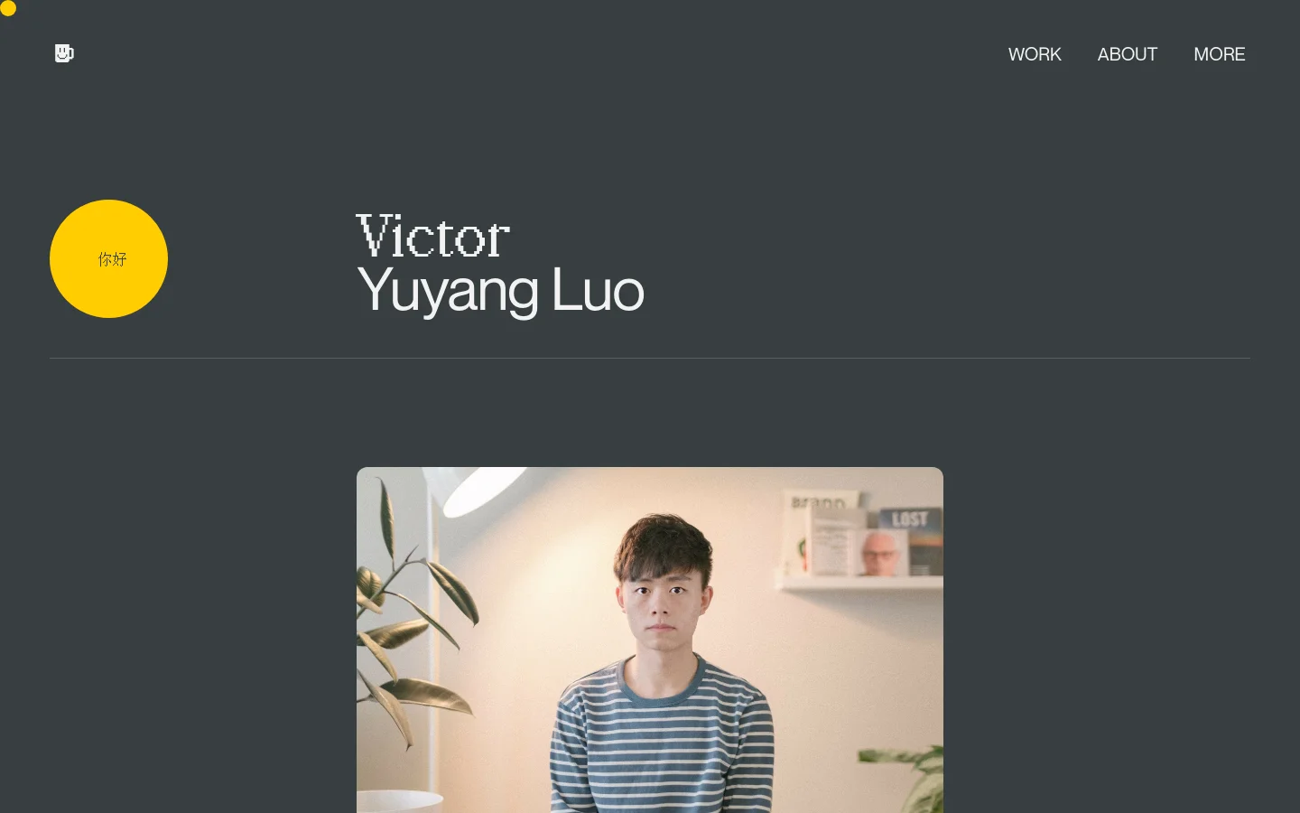 The desktop About page features a dark gray background with a minimalist layout. A large yellow circle containing Chinese characters sits to the left of the name 'Victor Yuyang Luo' in a white serif font, above a large portrait photo of a man. Navigation links for Work, About, and More are located in the top right corner.
