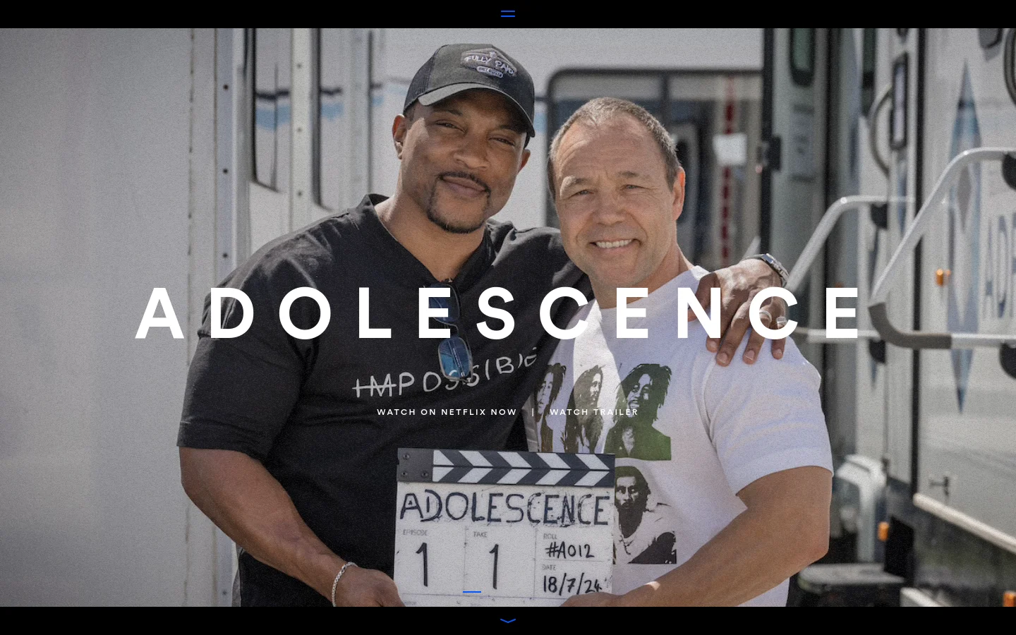 The desktop homepage features a large, cinematic hero image of two men smiling, with the title 'ADOLESCENCE' in bold white capital letters overlaid in the center. Below the title are text links for 'WATCH ON NETFLIX NOW' and 'WATCH TRAILER'. The layout is minimalist with a dark theme and a simple hamburger menu icon at the top center.