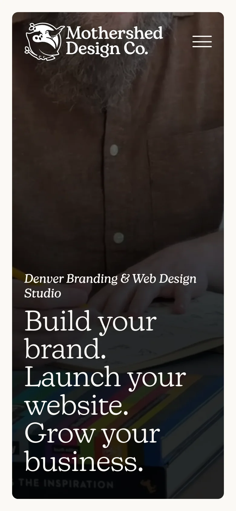 The mobile version presents a vertically oriented hero image of a person's torso and hands, with the same large white serif headline centered in the lower half. The navigation is condensed into a hamburger menu icon in the top right, and the primary call-to-action buttons from the desktop view are not immediately visible in this hero section.
