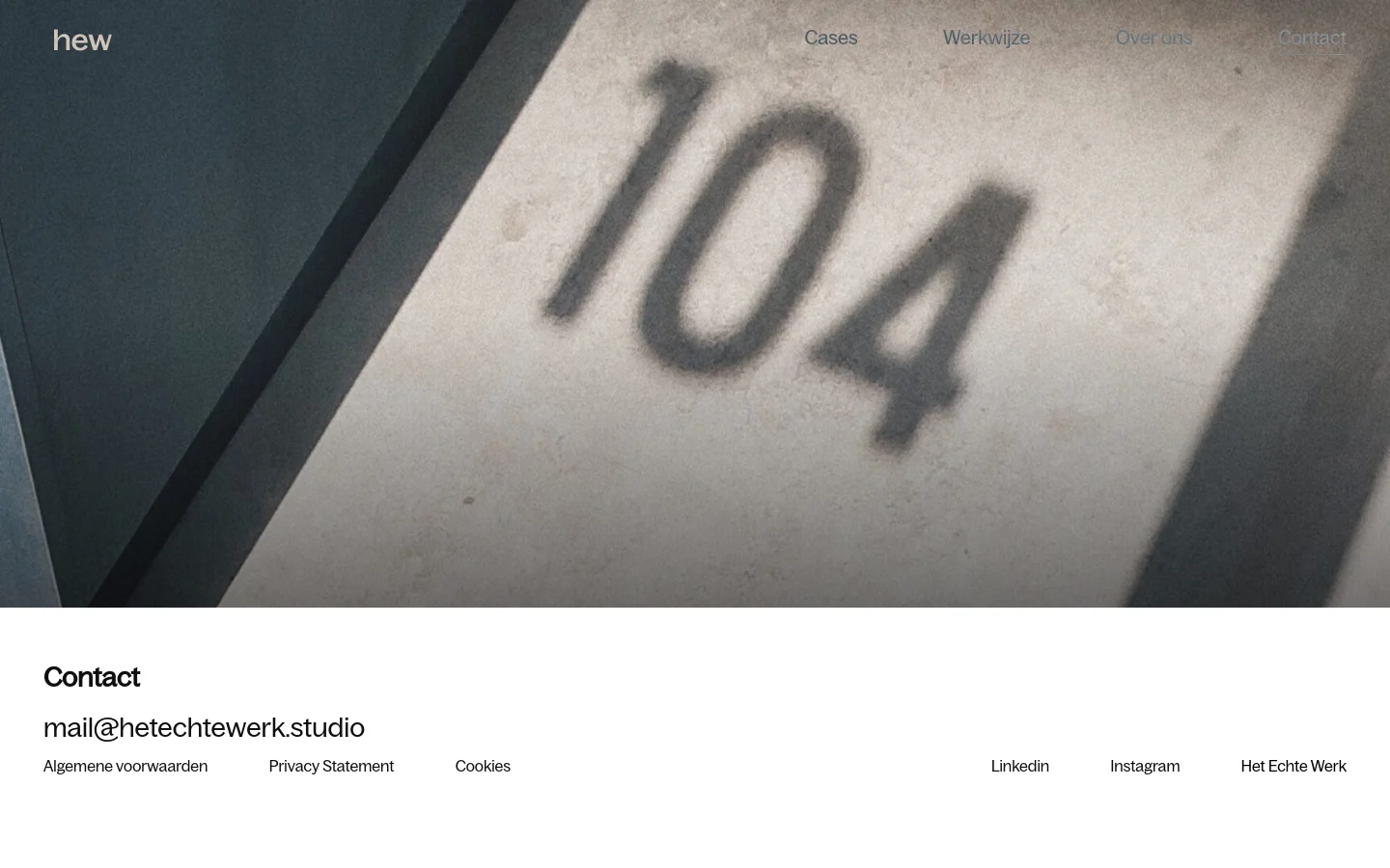 The desktop contact page features a large hero image of the number 104 on a textured wall under a dark blue and grey color palette. A minimalist navigation menu with links for Cases, Werkwijze, Over ons, and Contact is positioned at the top right, next to the 'hew' logo. Below the hero image, the contact section displays the headline 'Contact' followed by the email address and a footer with legal links and social media icons.