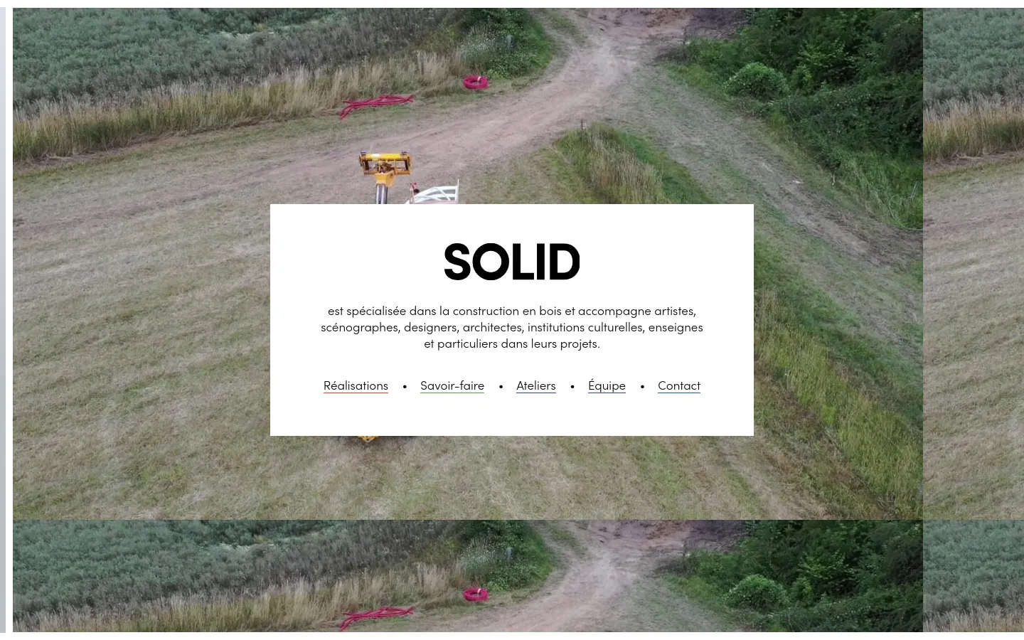 The desktop homepage features a large background image of a grassy field with a dirt path. A central white box contains the bold headline 'SOLID', a description of their wood construction services, and a horizontal navigation menu with links like Réalisations and Savoir-faire.