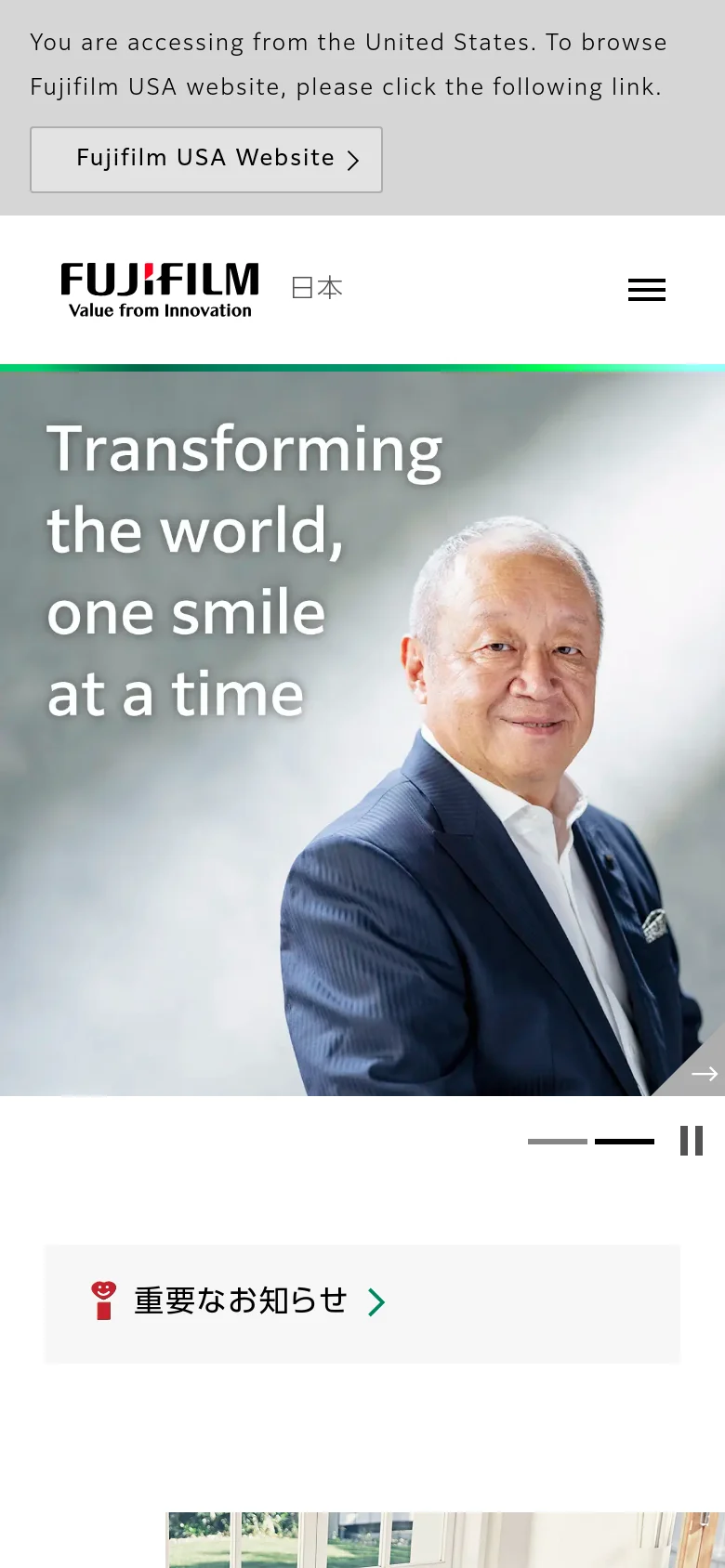 The mobile version presents a vertically stacked layout starting with a large hero image of a smiling man and the text 'Transforming the world, one smile at a time'. A hamburger menu icon replaces the desktop navigation, and the important news notification appears as a prominent button below the hero section. The content is simplified for vertical scrolling, focusing on large, touch-friendly image tiles.