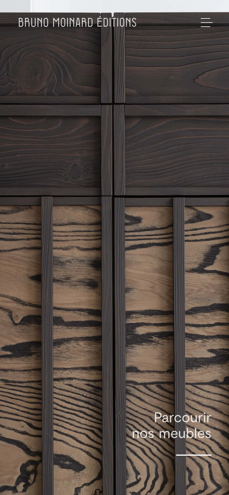 The mobile version maintains the minimalist aesthetic but stacks content vertically. The hero image of the dark wood sideboard fills the screen, with the brand name and a hamburger menu icon at the top. The 'Parcourir nos meubles' call to action is positioned at the bottom right over the wood texture.