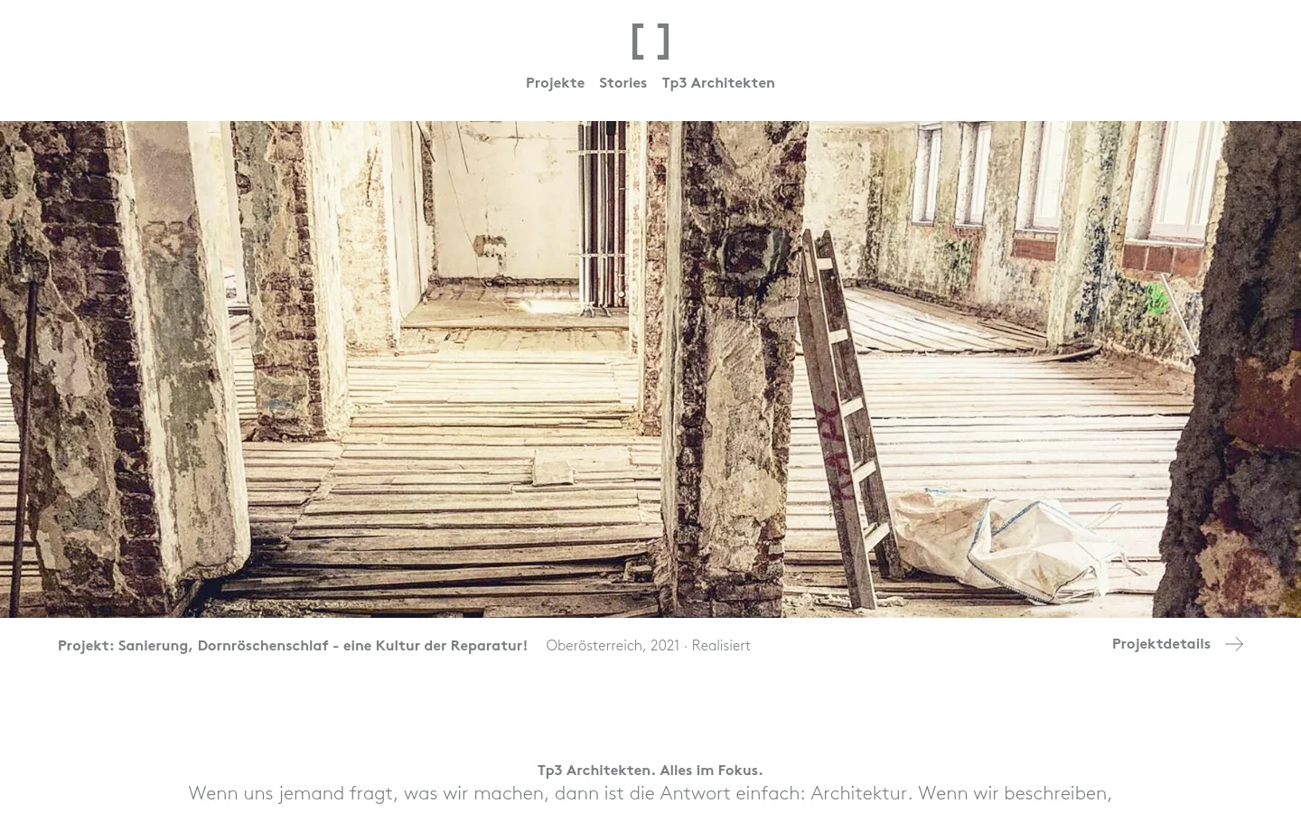The desktop website for Tp3 Architekten features a minimalist white layout with a large, full-width hero image showing the interior of a rustic, unfinished building with wooden floors and stone walls. A navigation menu with links to 'Projekte', 'Stories', and 'Tp3 Architekten' sits above the image, and a project title and 'Projektdetails' link are positioned below it.