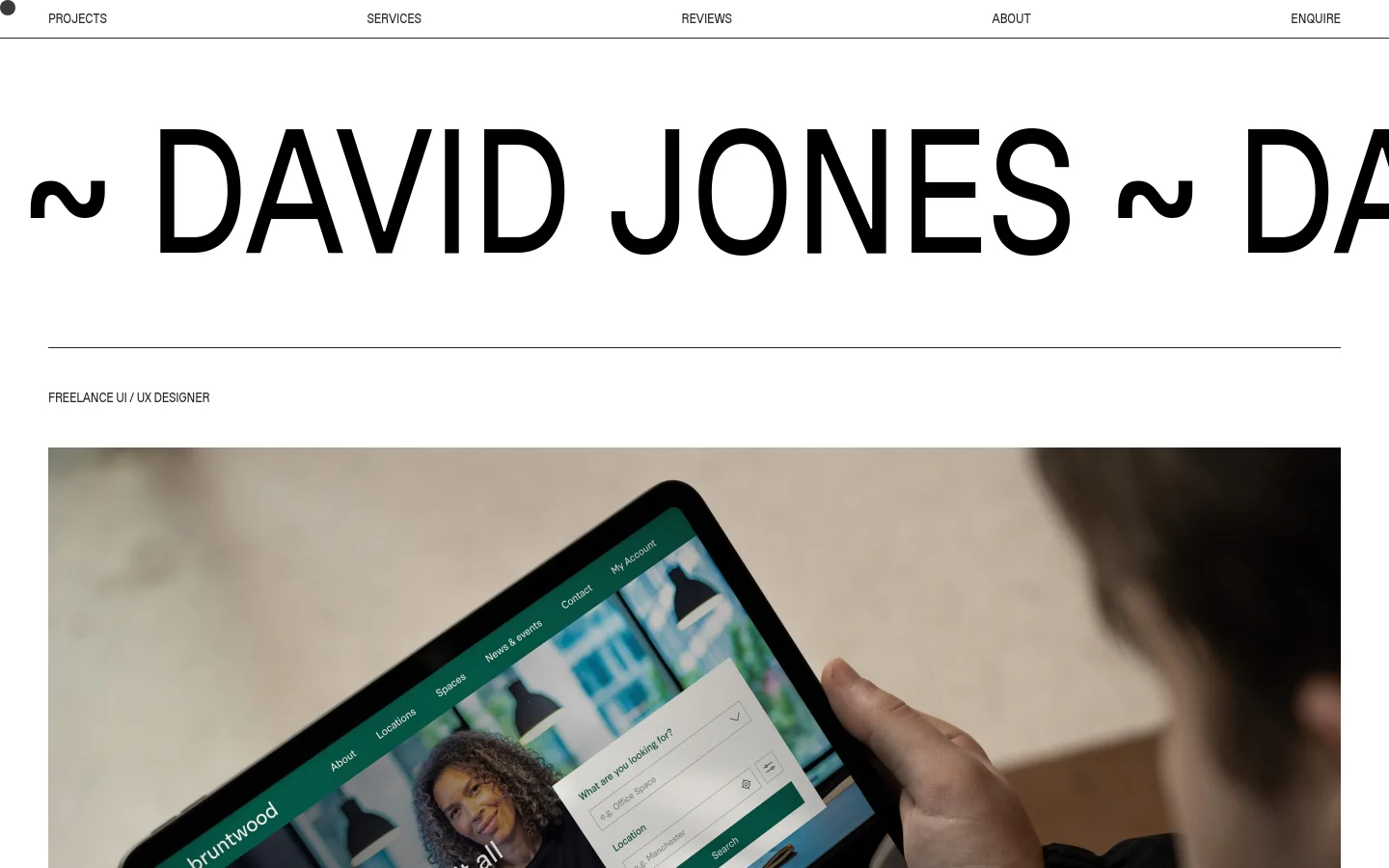 The desktop homepage features a minimalist white background with large black typography. A navigation menu sits at the top, followed by a massive hero headline and a large hero image showing a person holding a tablet displaying a website interface. Below, a scrolling text banner announces project availability, followed by an introductory section with a profile GIF and a 'Learn More' button.