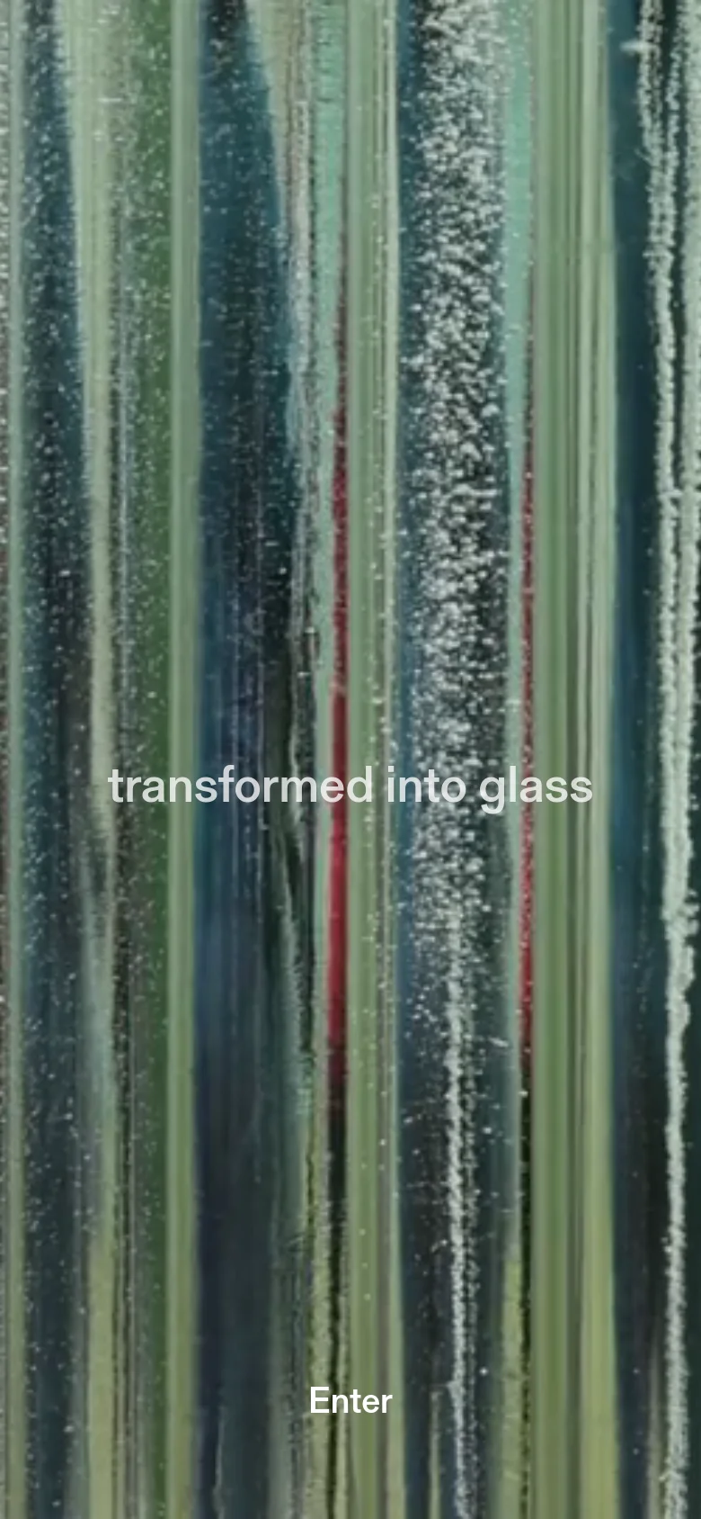 The mobile version maintains the full-screen background of vertical, textured glass pillars in muted tones. The layout is vertically oriented, with the text 'transformed into glass' and the 'Enter' button positioned centrally to fit the narrower aspect ratio.