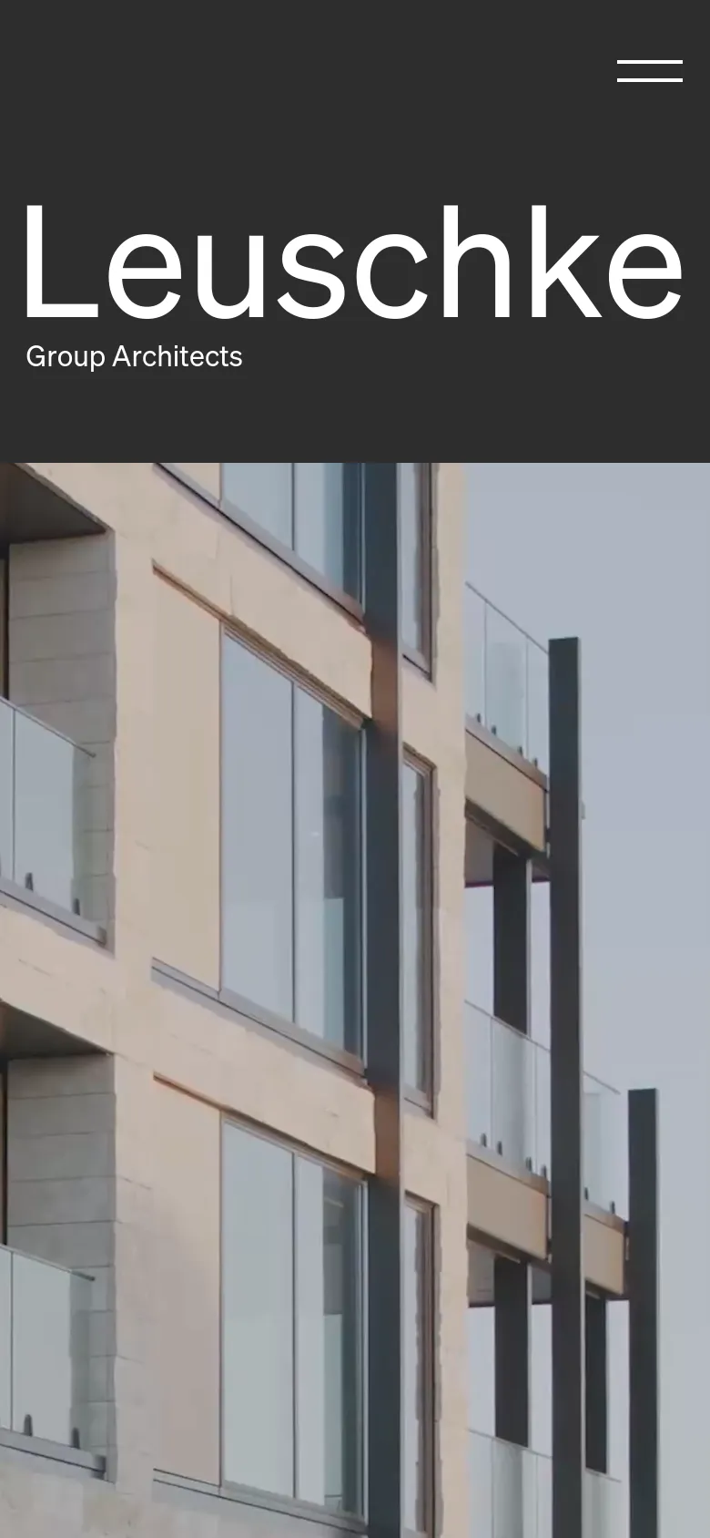 The mobile version uses a stacked layout with the large white 'Leuschke' heading prominently displayed against a dark charcoal background at the top. Below the text, a large architectural photograph of a building with glass balconies fills the remainder of the screen.
