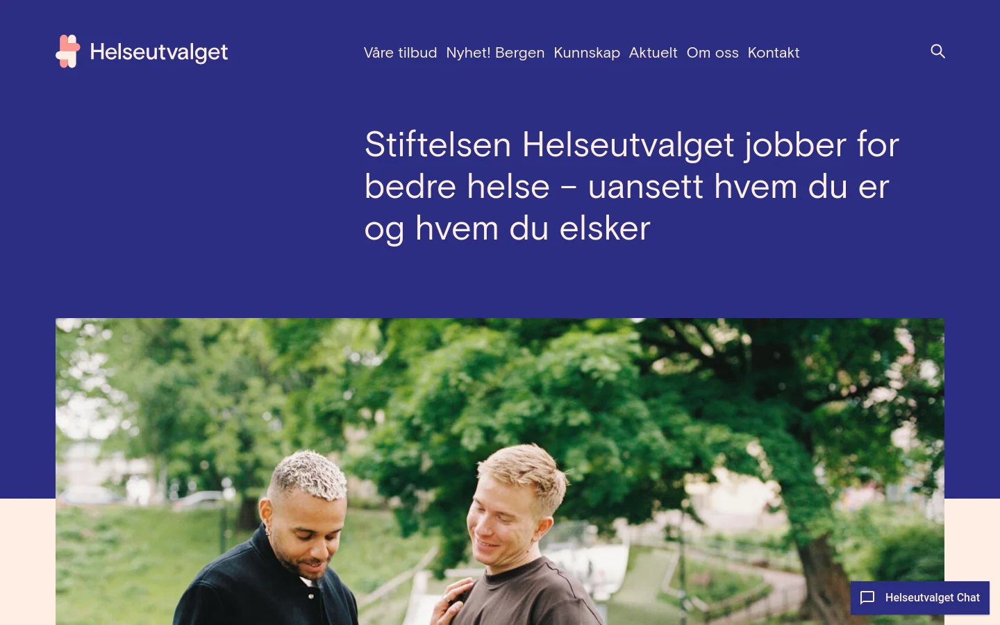 The desktop homepage features a deep blue header with the Helseutvalget logo and a navigation menu including links like 'Våre tilbud' and 'Kontakt'. A large hero section displays the headline 'Stiftelsen Helseutvalget jobber for bedre helse – uansett hvem du er og hvem du elsker' above a wide photograph of two men smiling outdoors. Below the image, there is a search input field and a button for 'Vanlige spørsmål' (Common questions), with a floating 'Helseutvalget Chat' button in the bottom right corner.