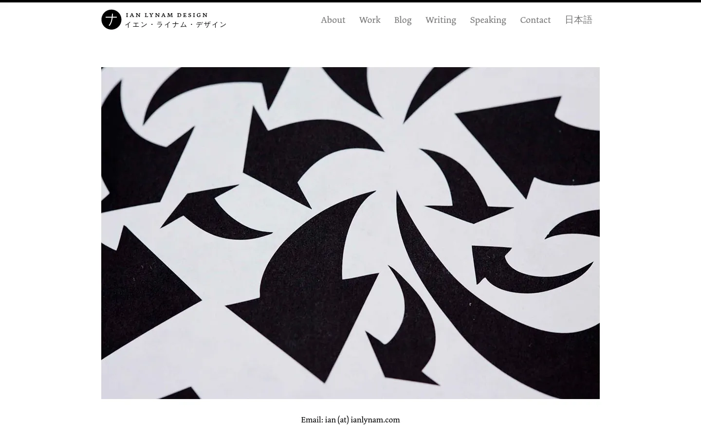 The desktop contact page features a minimalist white background with a large, central black and white abstract graphic of swirling arrow shapes. A top navigation bar includes the Ian Lynam Design logo and links for About, Work, Blog, Writing, Speaking, Contact, and Japanese. Contact information, including email, phone, and Instagram, is displayed in centered serif text below the hero image.