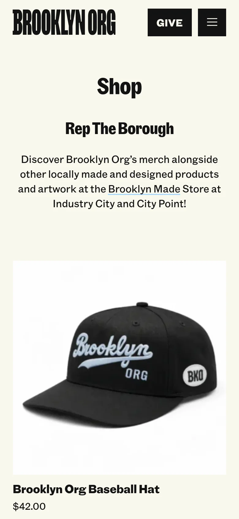 The mobile version maintains the cream background and centered text layout, but the navigation is condensed into a hamburger menu icon next to a 'Give' button. The product display is simplified into a single-column vertical scroll, showing the Brooklyn Org baseball hat prominently below the introductory text.