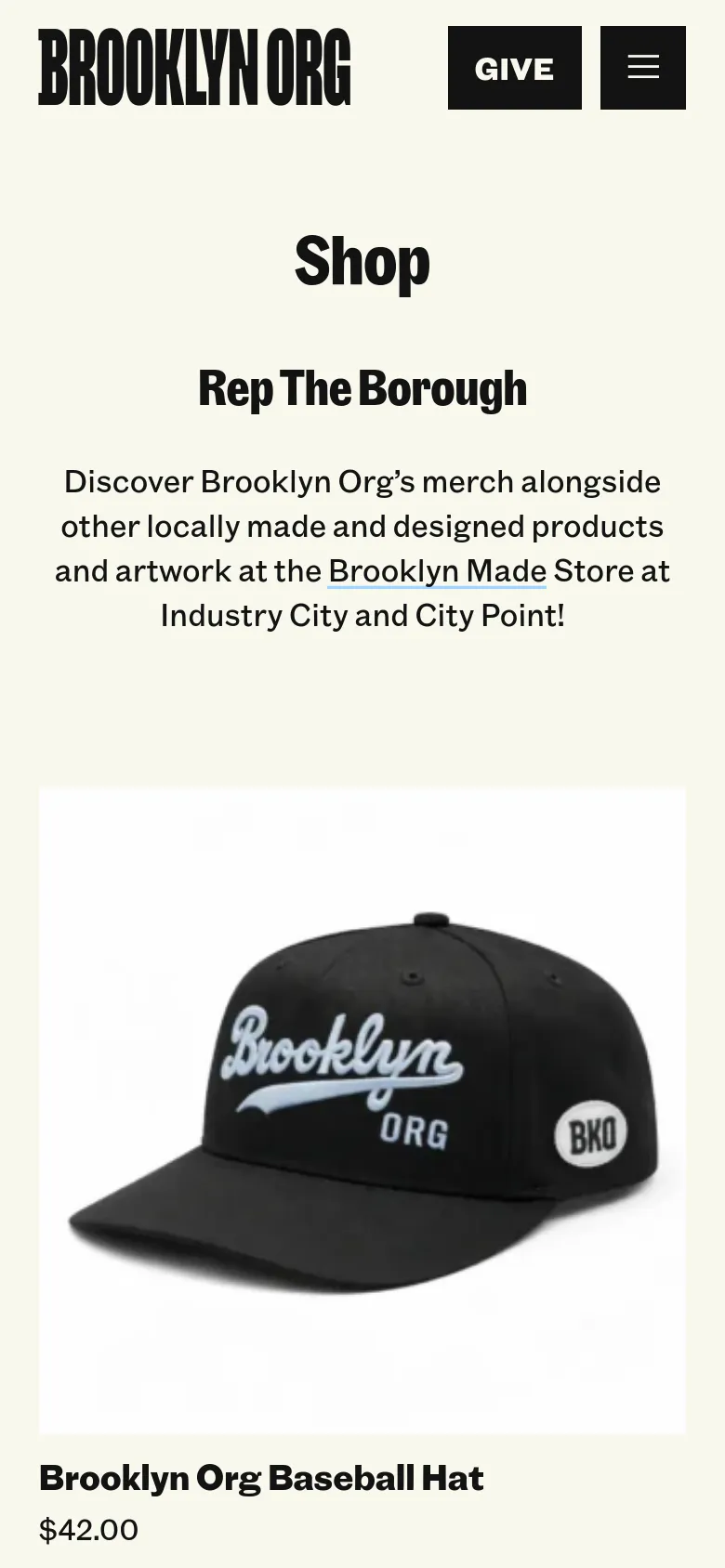 The mobile version maintains the cream background and centered text layout, but the navigation is condensed into a hamburger menu icon next to a 'Give' button. The product display is simplified into a single-column vertical scroll, showing the Brooklyn Org baseball hat prominently below the introductory text.