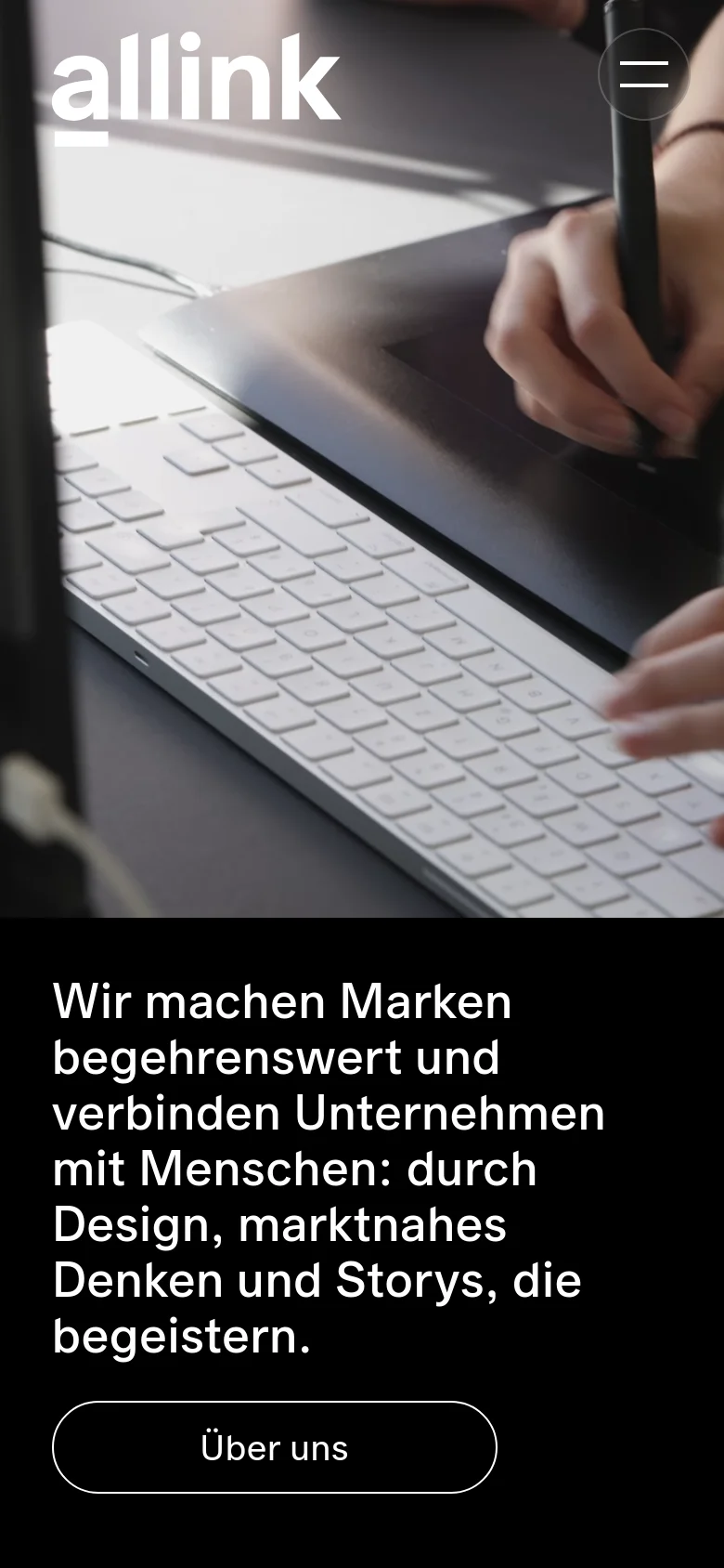 The mobile version presents a vertically stacked layout starting with a full-width hero image of a person using a digital tablet and keyboard. The headline and 'Über uns' button are positioned below the image on a black background. The navigation is condensed into a hamburger menu icon in the top right corner.
