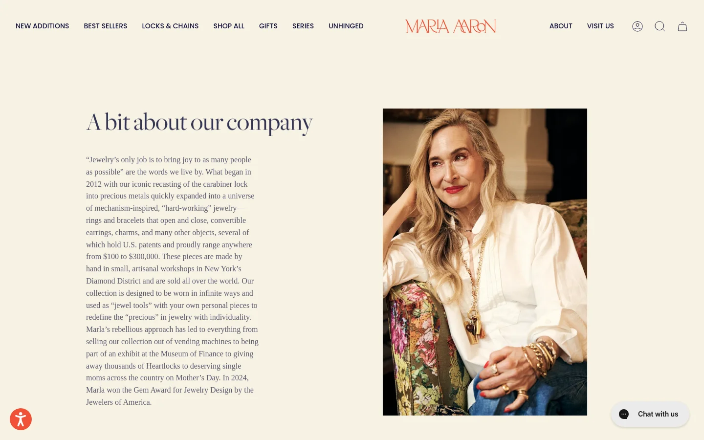 The About page features a minimalist layout with a cream background and serif typography. A large headline 'A bit about our company' sits next to a long text block describing the brand's history, while a vertical portrait of a smiling woman wearing gold jewelry occupies the right side of the screen. The desktop navigation includes links for New Additions, Best Sellers, and various jewelry categories.
