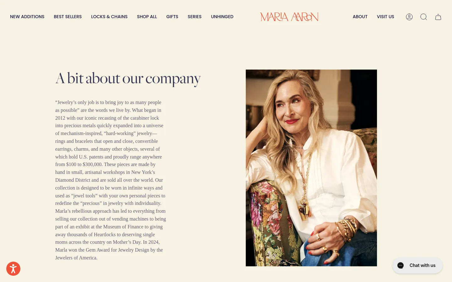 The About page features a minimalist layout with a cream background and serif typography. A large headline 'A bit about our company' sits next to a long text block describing the brand's history, while a vertical portrait of a smiling woman wearing gold jewelry occupies the right side of the screen. The desktop navigation includes links for New Additions, Best Sellers, and various jewelry categories.