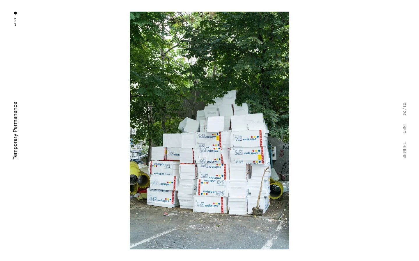 The desktop version features a minimalist white layout with vertical navigation text on the left and right margins. A large, vertical portrait photograph of stacked white Styrofoam boxes under green trees dominates the center, with the title 'Temporary Permanence' appearing in the sidebar.