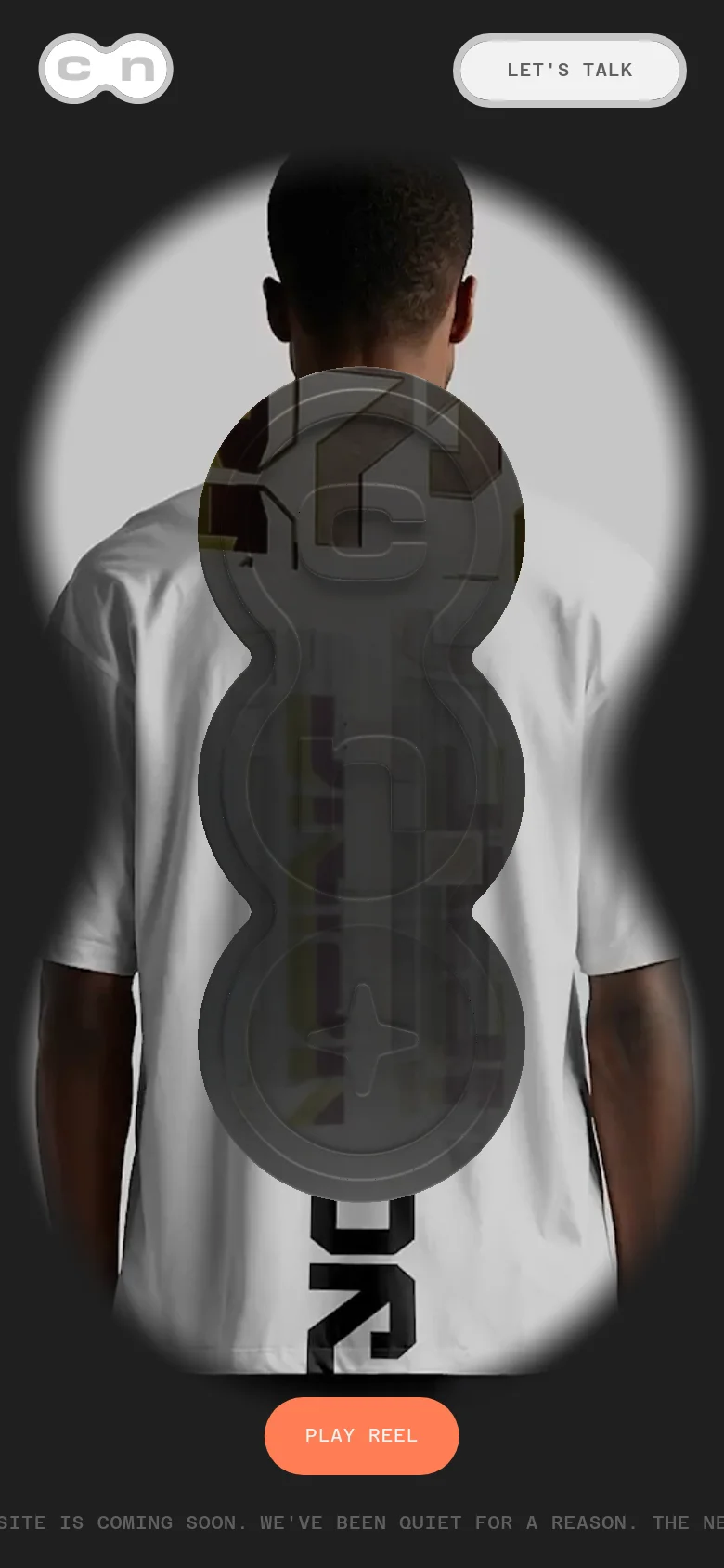 The mobile version presents a vertically oriented layout with a large, centered hero image of a person's back through a circular lens effect. The 'cn' logo is at the top left, and a prominent 'LET'S TALK' button is at the top right. A large, orange 'PLAY REEL' button is centered near the bottom against a dark background.