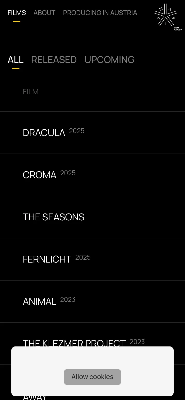 The mobile version maintains the black and white minimalist aesthetic but uses a vertical layout. The navigation links are condensed, and the film list is presented in a single-column format for easier scrolling. A large cookie consent banner appears at the bottom of the screen.