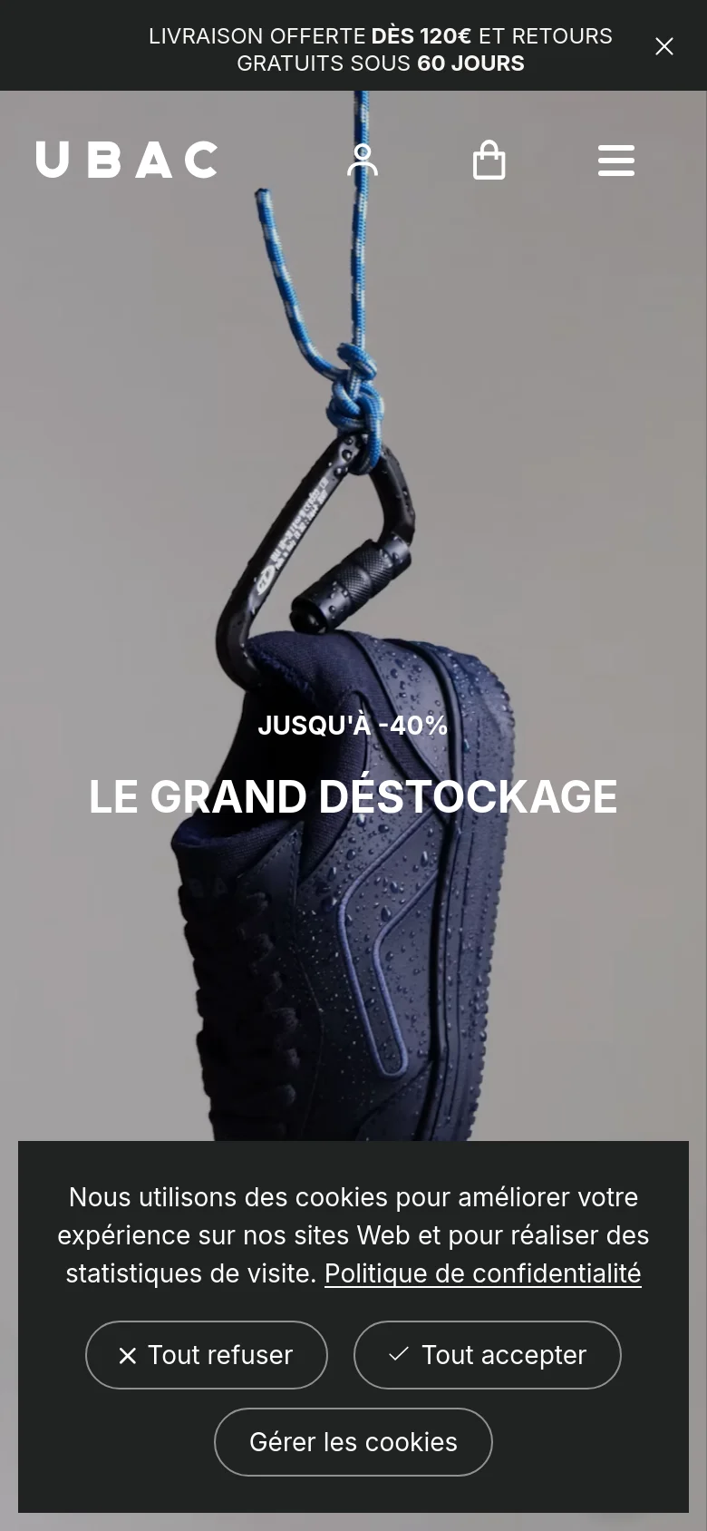 The mobile version shows a vertically oriented hero image of the waterproof sneaker with the headline 'JUSQU'À -40% LE GRAND DÉSTOCKAGE' centered in white text. The layout is simplified with a hamburger menu, user icon, and shopping bag icon in the header. A large cookie consent banner appears at the bottom of the screen.