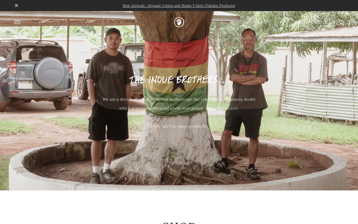 The homepage features a large hero image of two men standing by a tree with a Ghana flag, overlaid with the brand name 'THE INOUE BROTHERS' and a mission statement about social justice. A navigation bar at the top includes a menu icon, a central fist logo, and shopping icons, while a dark announcement bar sits at the very top. Below the hero section, a 'SHOP' heading introduces a categorized list of product links.