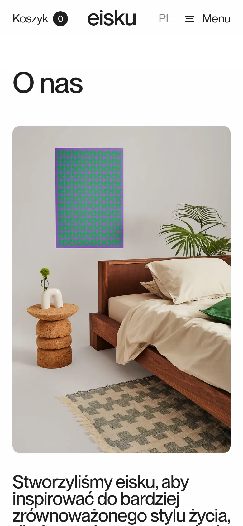 The mobile version presents a vertical layout starting with the eisku logo, language selector, and a hamburger menu icon. Below the 'O nas' headline, a large lifestyle photograph shows a wooden bed with beige linens, a cork side table, and a patterned rug against a neutral wall. The brand mission text is positioned directly underneath the image.