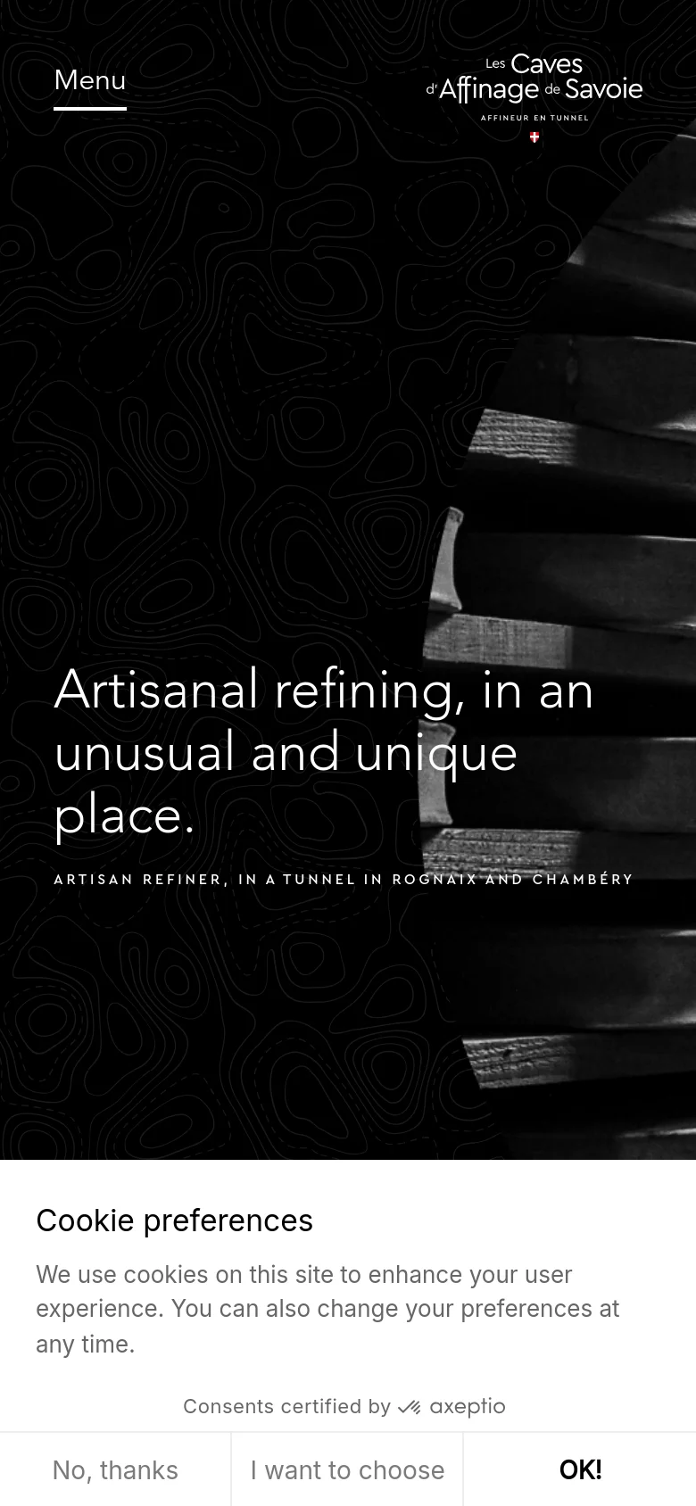 The mobile version maintains the dark aesthetic and large white typography, but the layout is vertically stacked to fit the narrow screen. The cheese wheel imagery is cropped and repositioned, and the cookie preference banner expands to occupy the full width of the bottom of the screen.