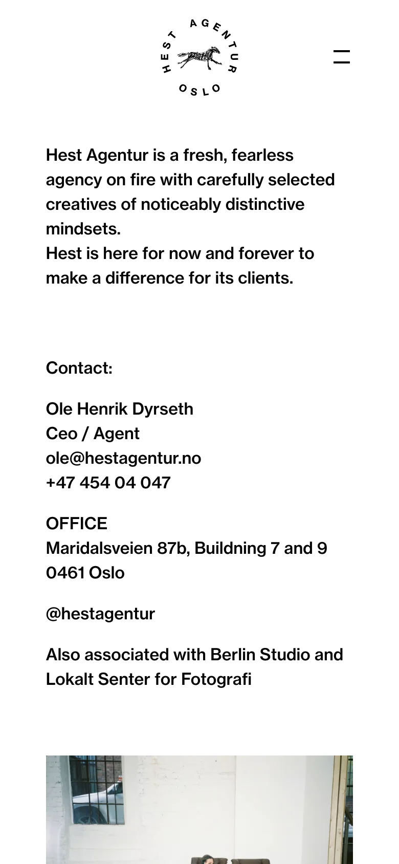The mobile version uses a single-column vertical layout on a white background. The agency logo and a hamburger menu icon appear at the top, followed by the agency description and contact information. The large industrial interior photograph is positioned at the bottom of the screen.