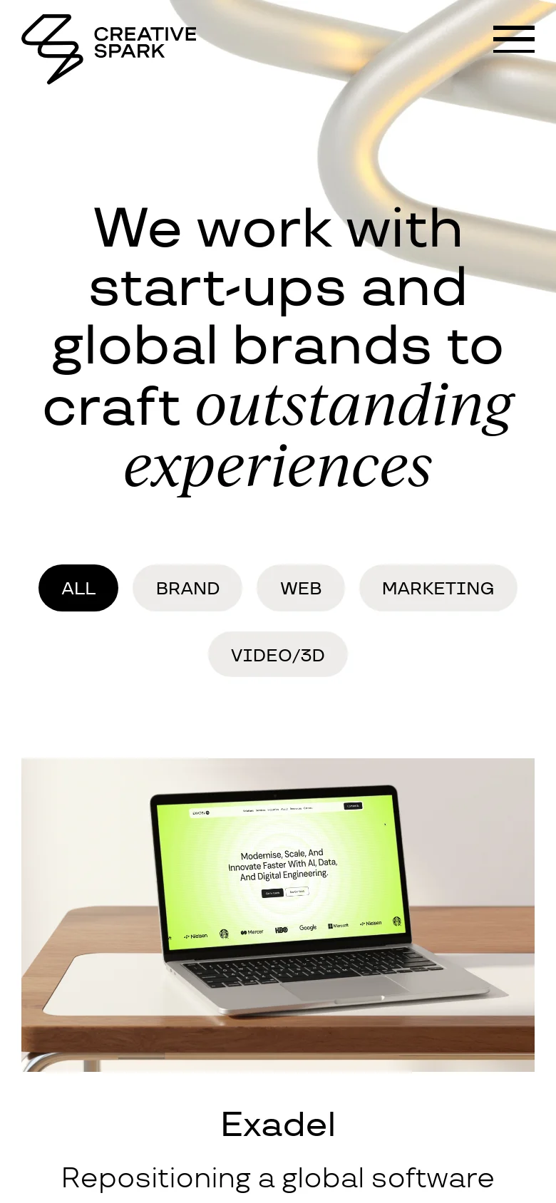 The mobile version presents a vertically stacked layout with the Creative Spark logo and a hamburger menu icon at the top. The large headline is centered over the abstract 3D silver imagery, followed by the filter buttons arranged in two rows. Below the hero section, a project card for 'Exadel' is visible, featuring a large image of a laptop on a wooden desk.