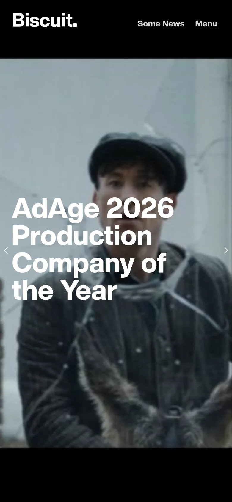 The mobile version maintains the dark aesthetic and large hero imagery but scales the layout for a vertical screen. The headline 'AdAge 2026 Production Company of the Year' is centered over a portrait-oriented shot of a man, with the 'Biscuit.' logo and 'Menu' options positioned at the top.