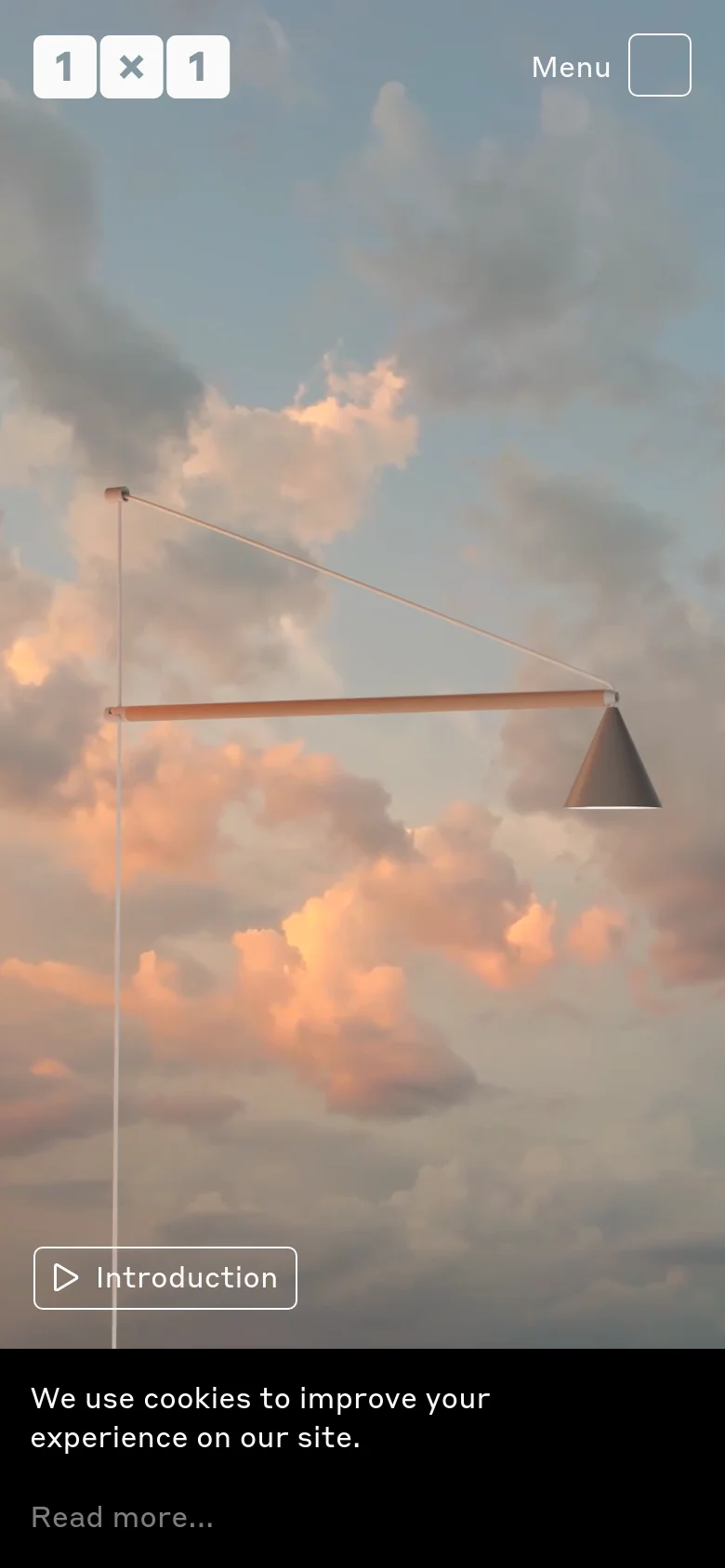 The mobile version displays a full-screen hero image of a minimalist lamp against a cloudy sunset sky. The navigation is condensed into a 'Menu' button with a square icon at the top right, and a large 'Introduction' button is positioned at the bottom left. A cookie consent banner appears at the bottom of the screen.