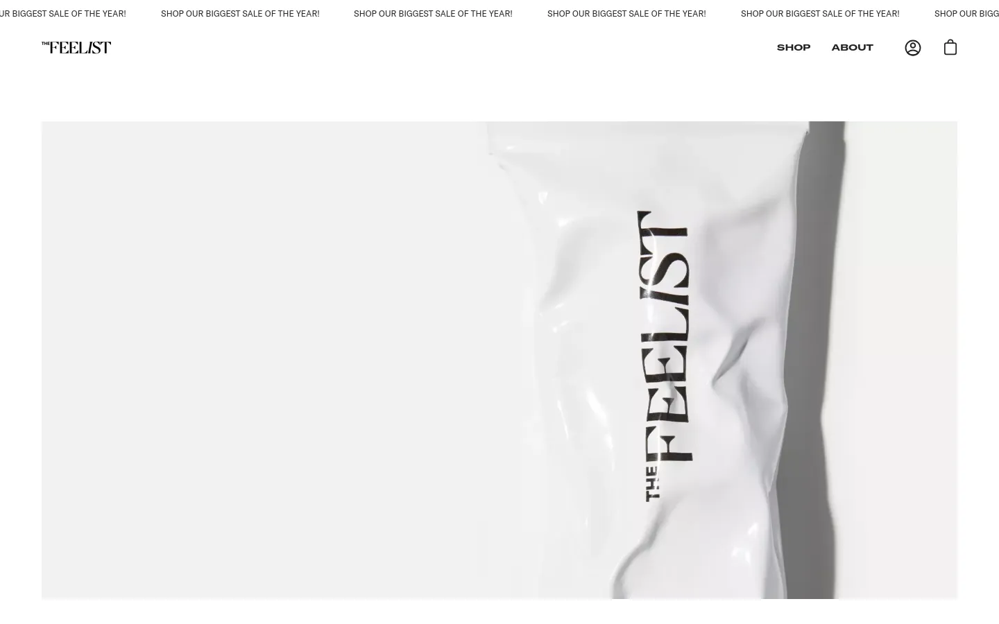 The desktop About Us page features a minimalist design with a white background and black text. A large hero image shows a close-up of a white product package with 'THE FEELIST' printed vertically in black. The navigation menu at the top includes the brand logo, 'SHOP', 'ABOUT', a user icon, and a shopping bag icon.